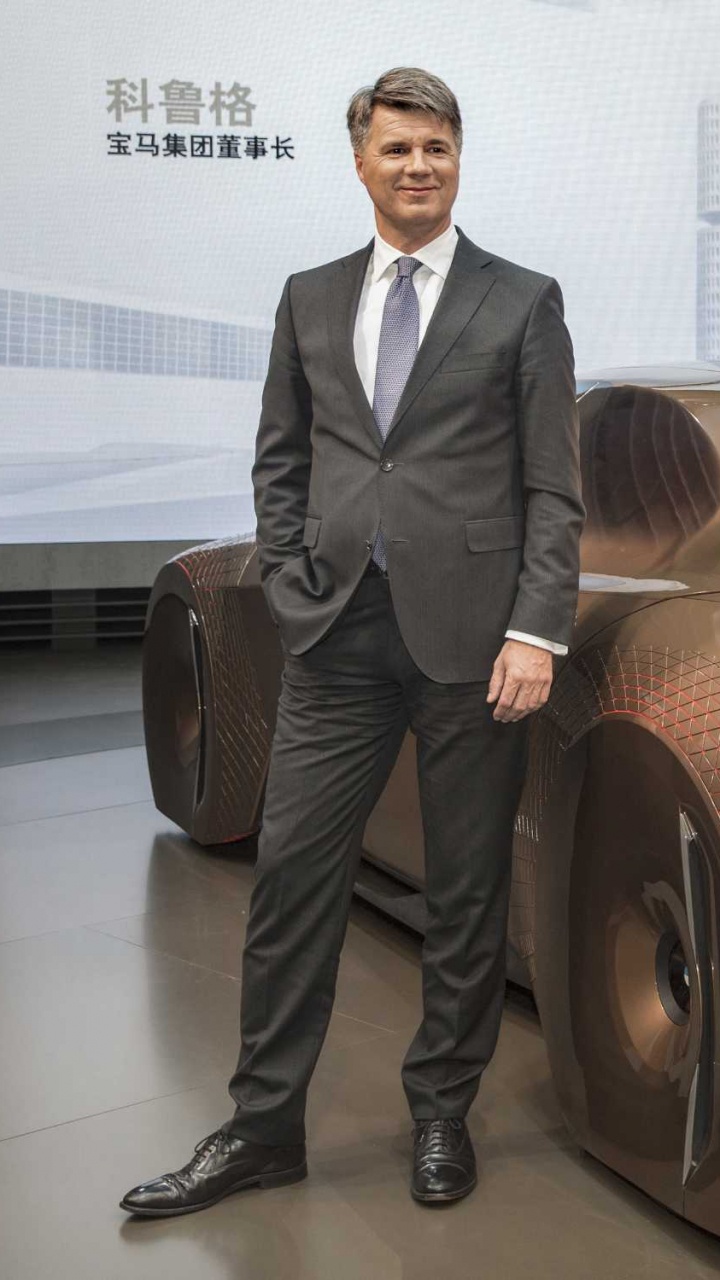 Man in Black Suit Standing Beside Red Car. Wallpaper in 720x1280 Resolution