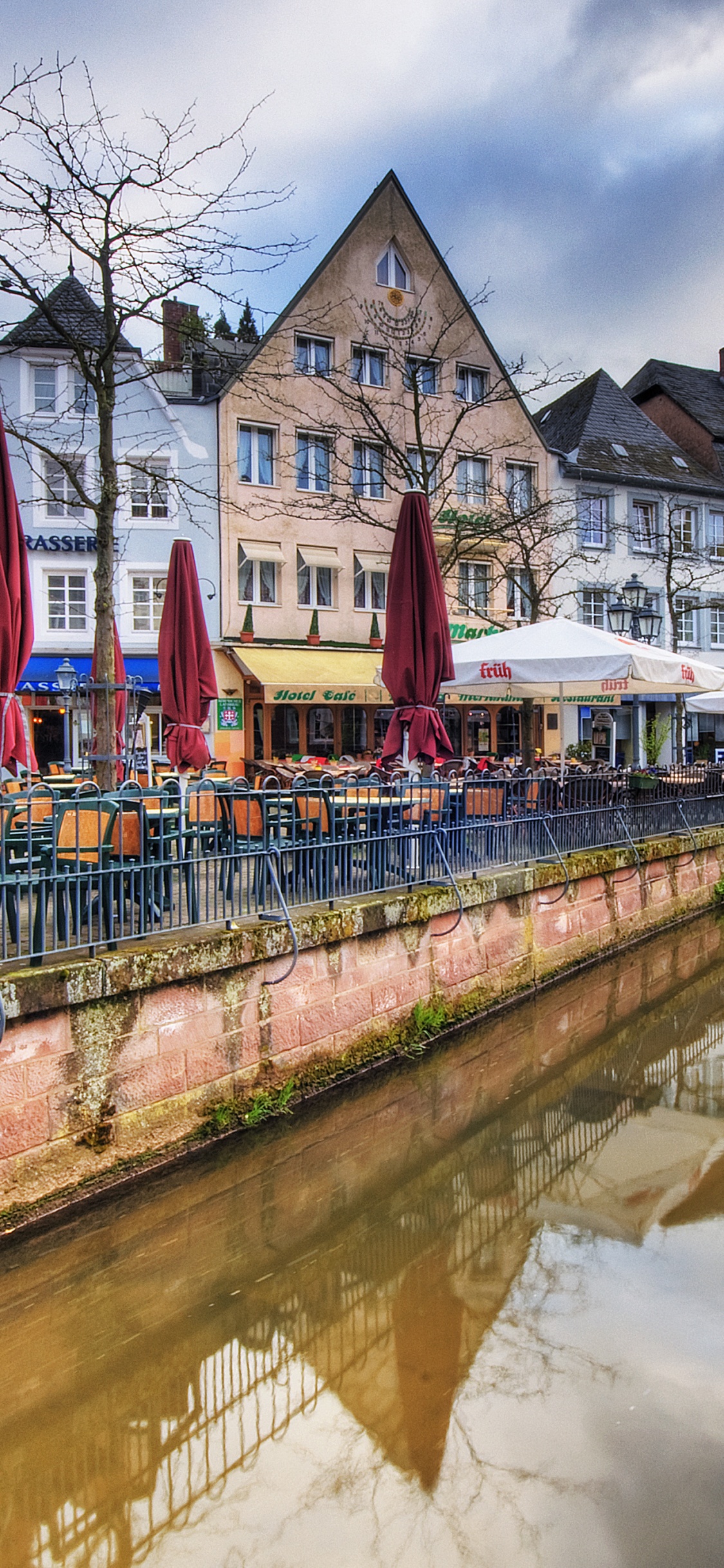 Red and White Concrete Building Beside River During Daytime. Wallpaper in 1125x2436 Resolution