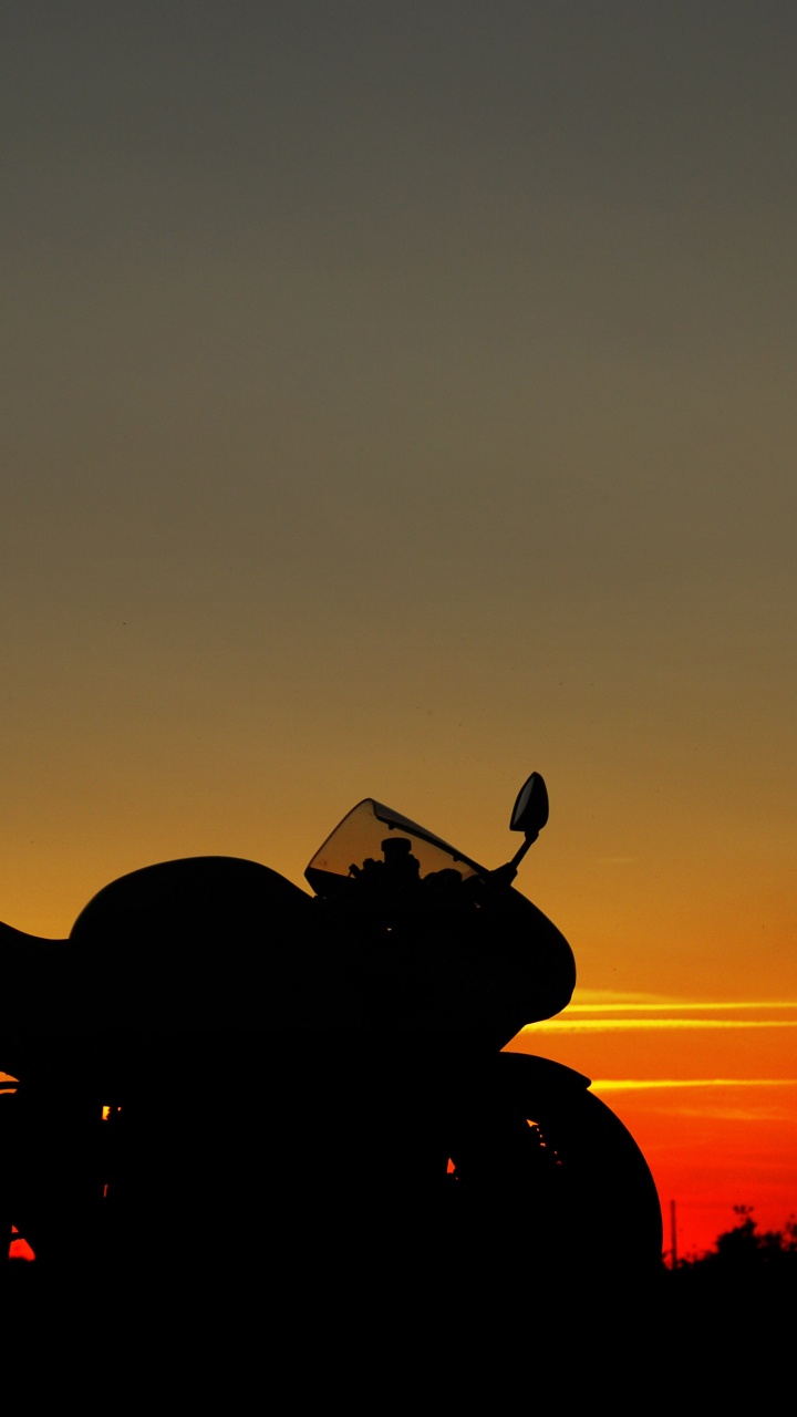 Silhouette Des Motorrads Bei Sonnenuntergang. Wallpaper in 720x1280 Resolution