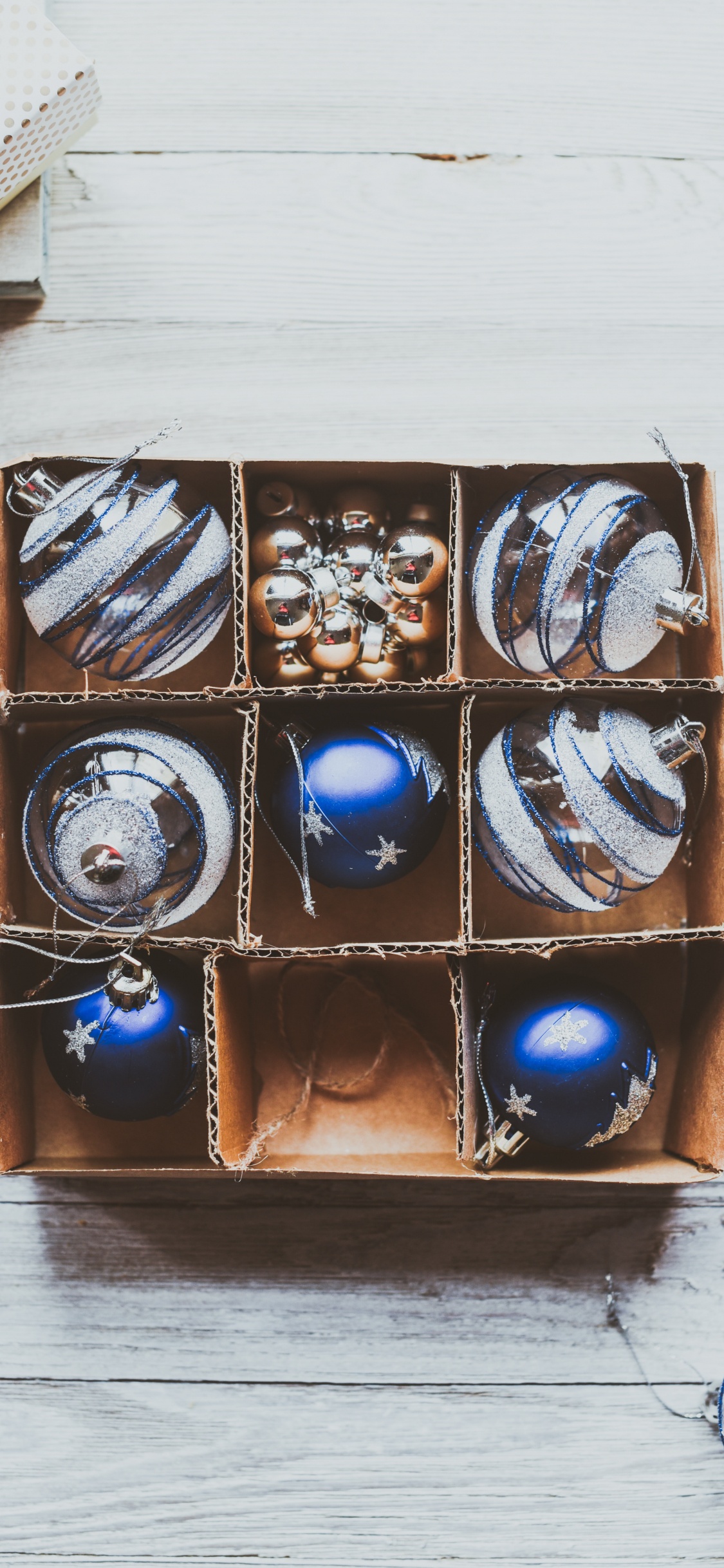 Boules Bleues et Argentées Dans Une Boîte en Bois Marron. Wallpaper in 1125x2436 Resolution