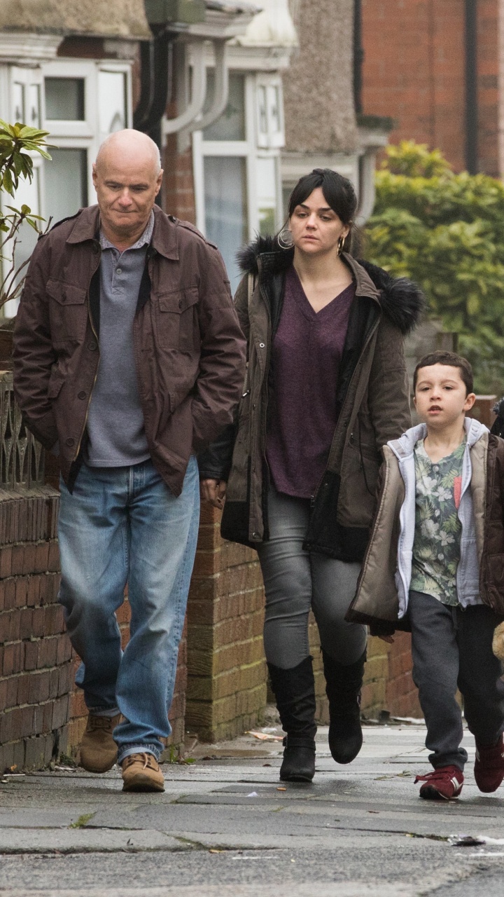 Mann in Schwarzer Jacke Steht Neben Frau in Braunem Mantel. Wallpaper in 720x1280 Resolution