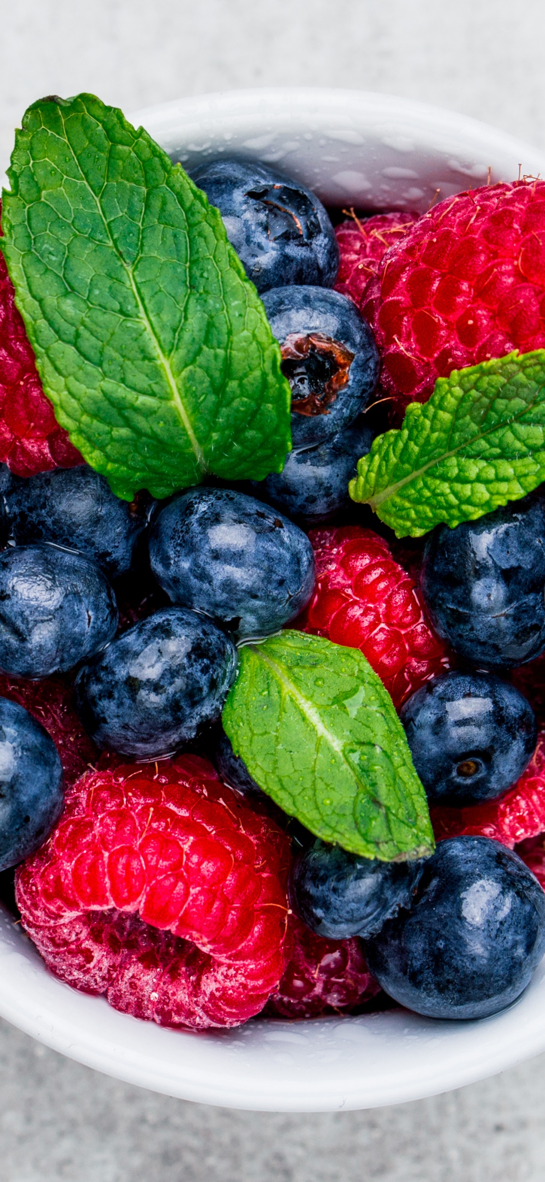 Raspberry and Blueberry in White Ceramic Bowl. Wallpaper in 1125x2436 Resolution