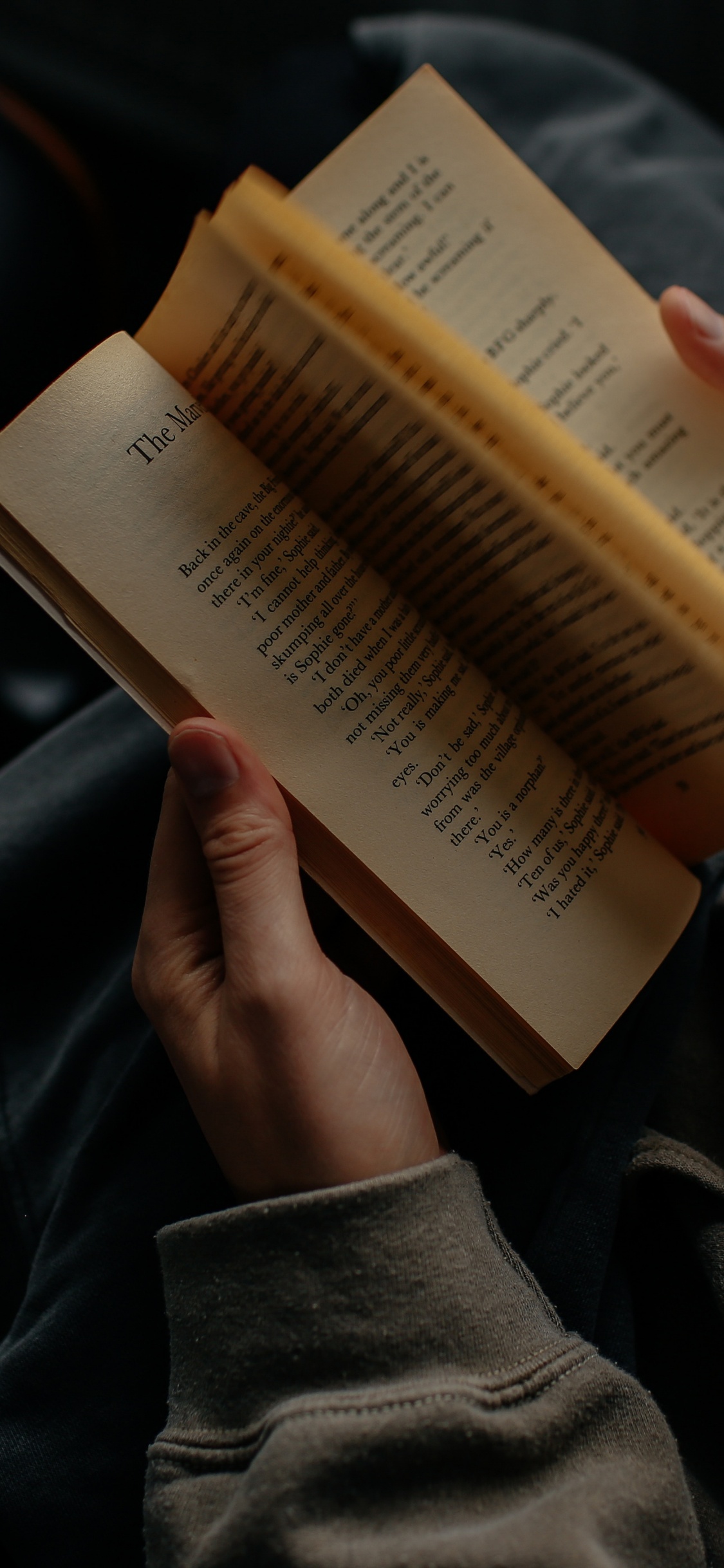 Persona Que Sostiene el Libro en el Regazo. Wallpaper in 1125x2436 Resolution