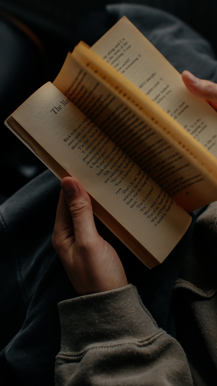 Persona Que Sostiene el Libro en el Regazo. Wallpaper in 750x1334 Resolution
