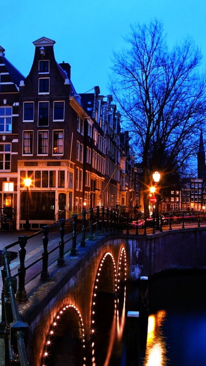 Edificio de Hormigón Marrón Cerca Del Río Durante la Noche. Wallpaper in 720x1280 Resolution