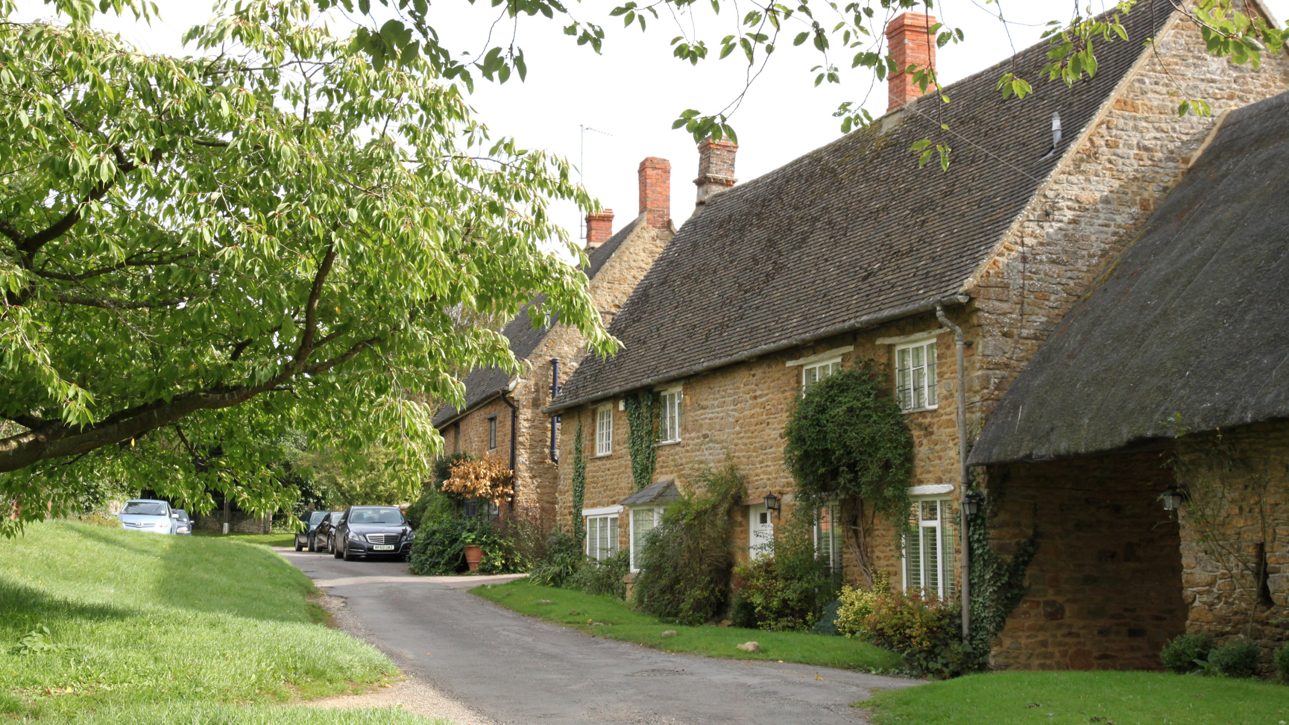 Suv Noir Garé à Côté D'un Bâtiment en Briques Brunes Pendant la Journée. Wallpaper in 2560x1440 Resolution