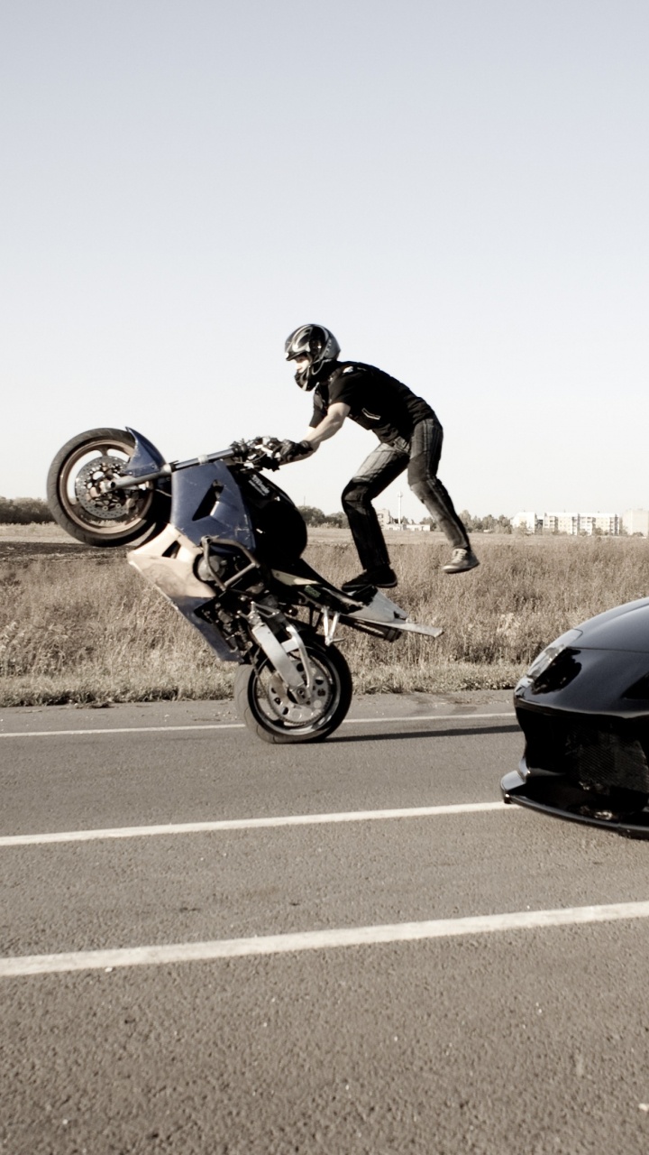 Homme en Veste Noire Équitation Vélo de Sport Bleu Sur Route Asphaltée Grise Pendant la Journée. Wallpaper in 720x1280 Resolution