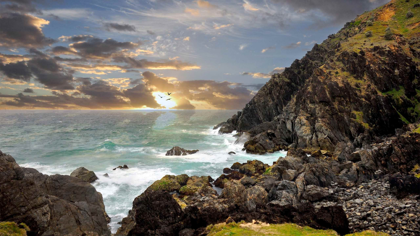 Brauner Felsiger Berg am Meer Bei Sonnenuntergang. Wallpaper in 1366x768 Resolution