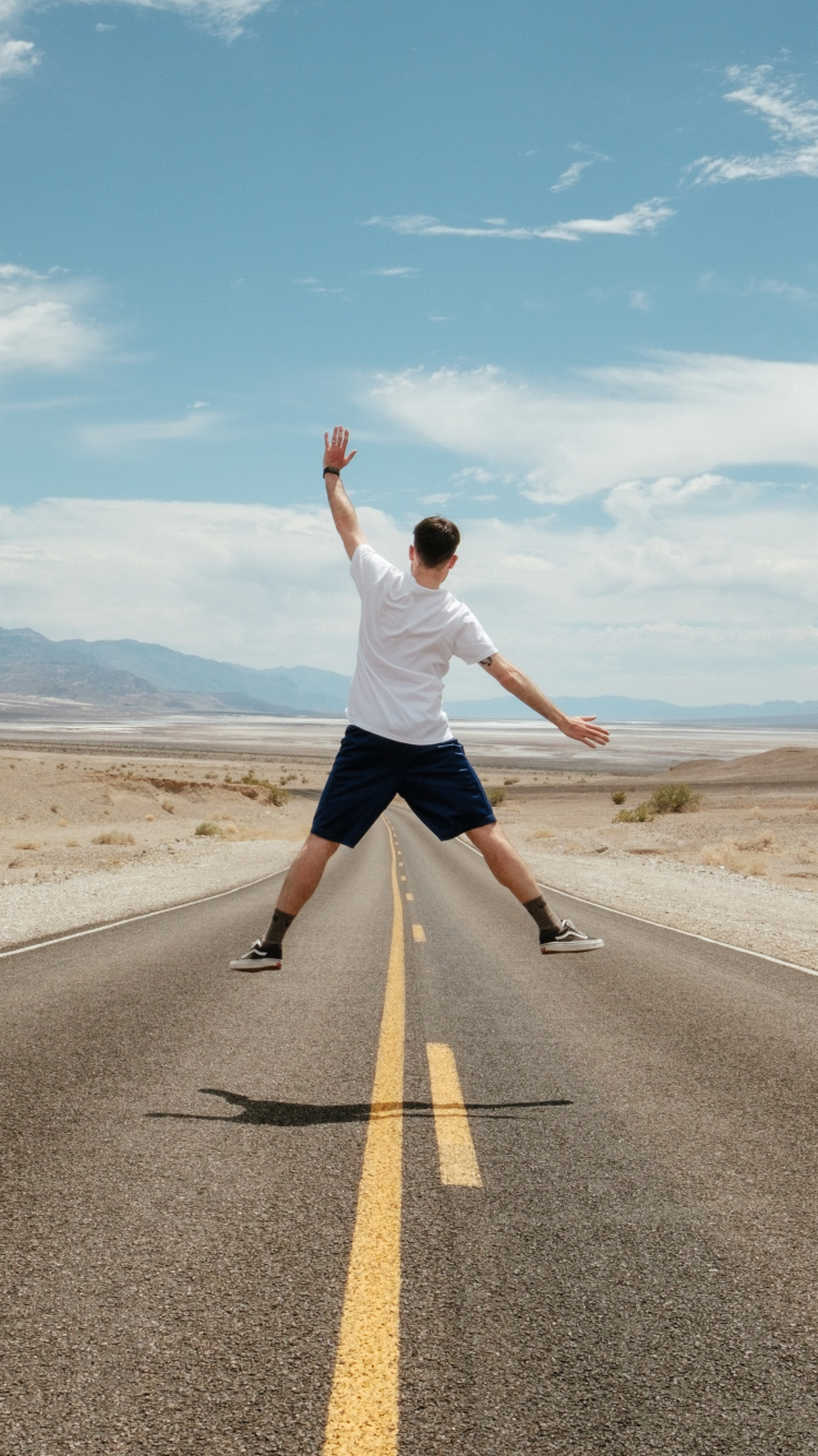 Homme en T-shirt Blanc et Short Noir Courant Sur Une Route Goudronnée Grise Sous Bleu Et. Wallpaper in 750x1334 Resolution