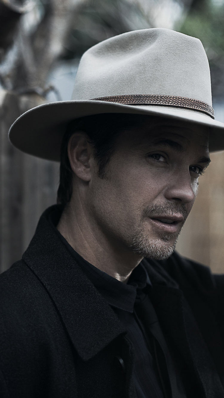 L'homme en Chemise Boutonnée Noire Portant un Chapeau Fedora Marron. Wallpaper in 750x1334 Resolution