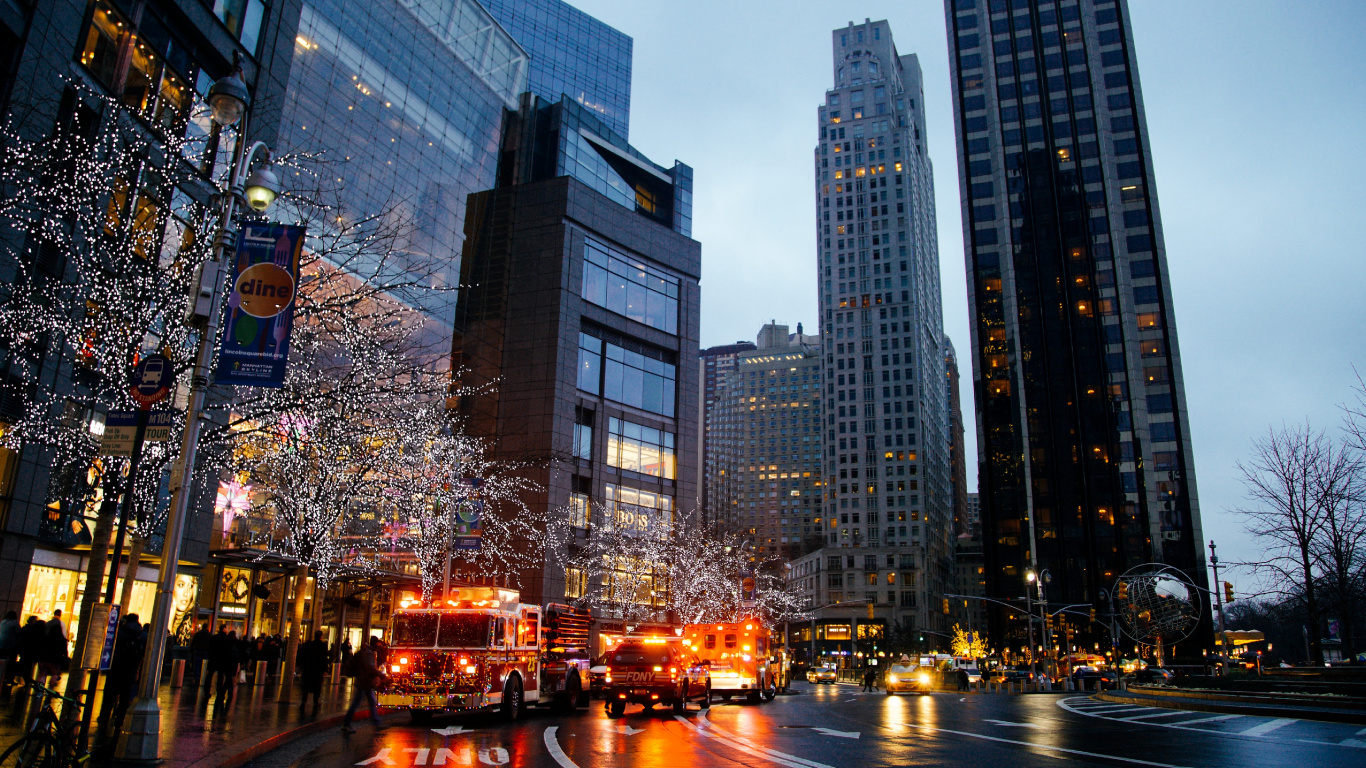 Autos Auf Der Straße in Der Nähe Von Hochhäusern Während Der Nacht. Wallpaper in 1366x768 Resolution