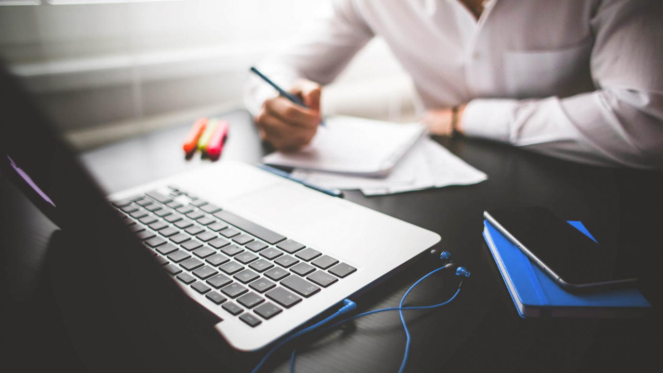Person in White Dress Shirt Using Macbook Pro. Wallpaper in 1366x768 Resolution