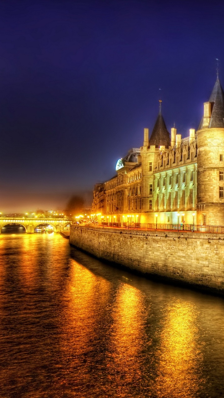 Brown Concrete Building Near Body of Water During Night Time. Wallpaper in 720x1280 Resolution