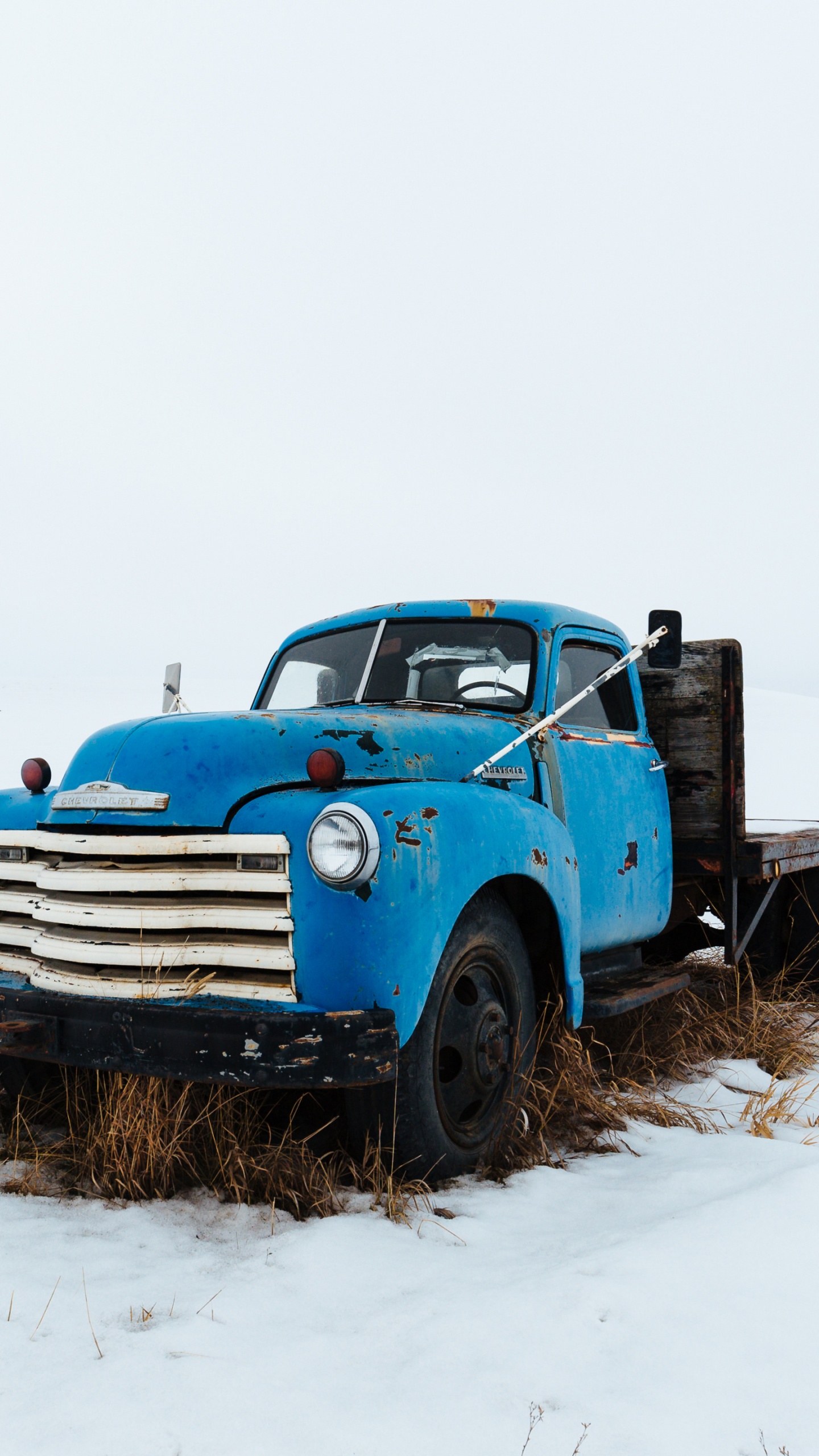 Camion Bleu Sur Sol Couvert de Neige Pendant la Journée. Wallpaper in 1440x2560 Resolution