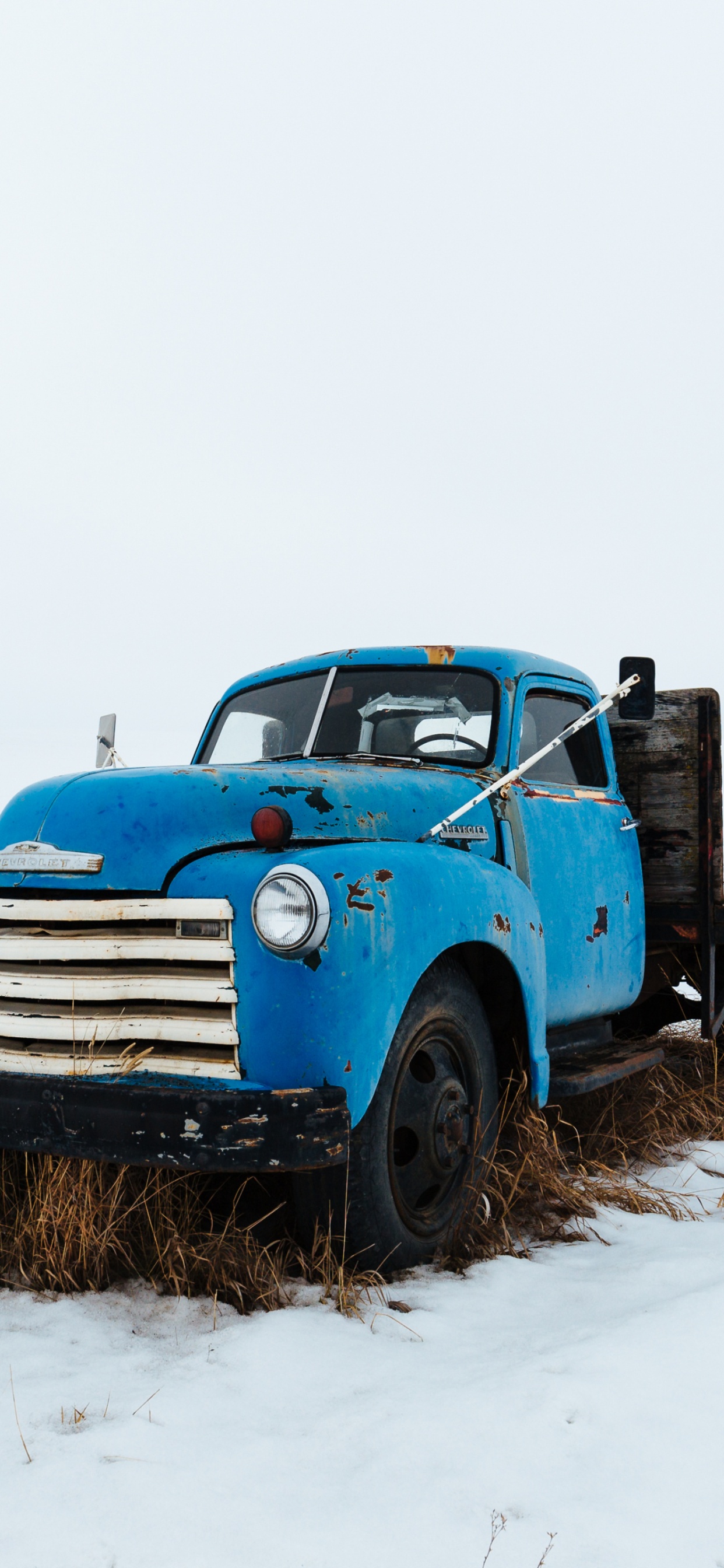 Camión Azul Sobre Suelo Cubierto de Nieve Durante el Día. Wallpaper in 1242x2688 Resolution