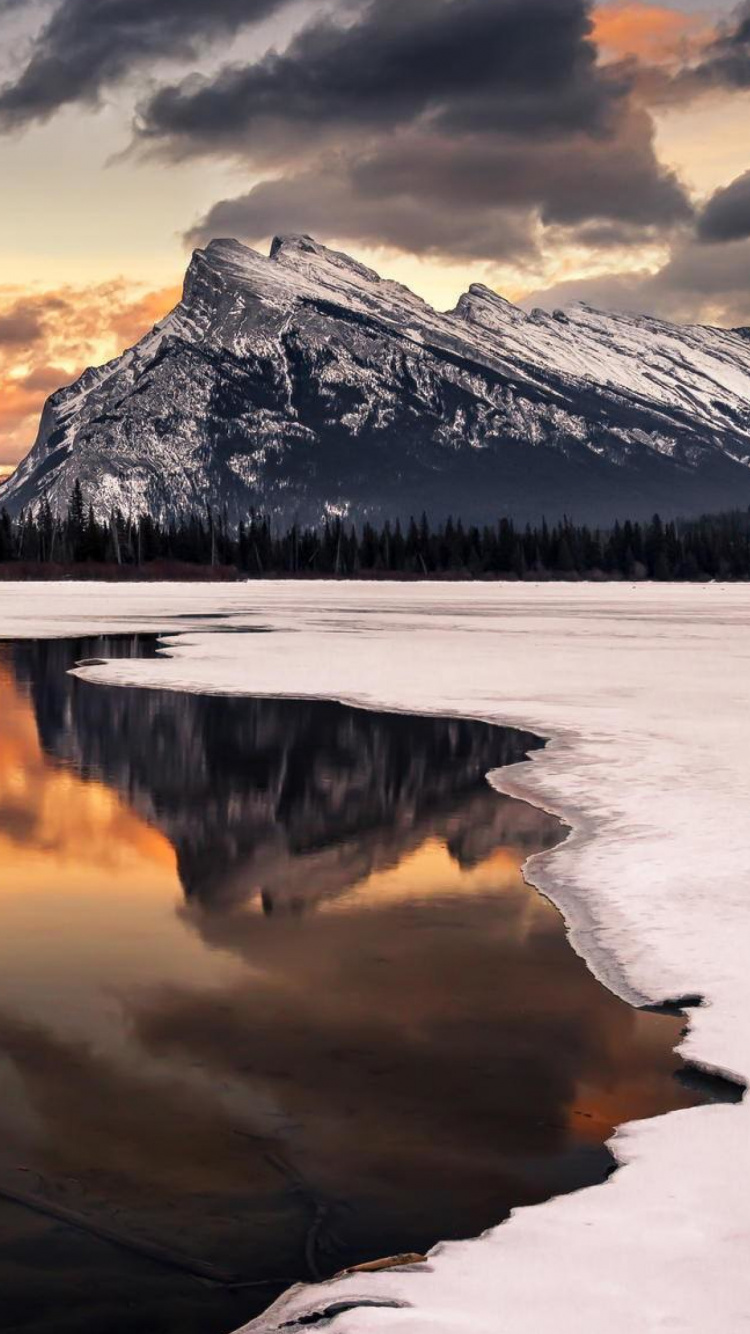 Snow Covered Mountain Near Body of Water During Daytime. Wallpaper in 750x1334 Resolution