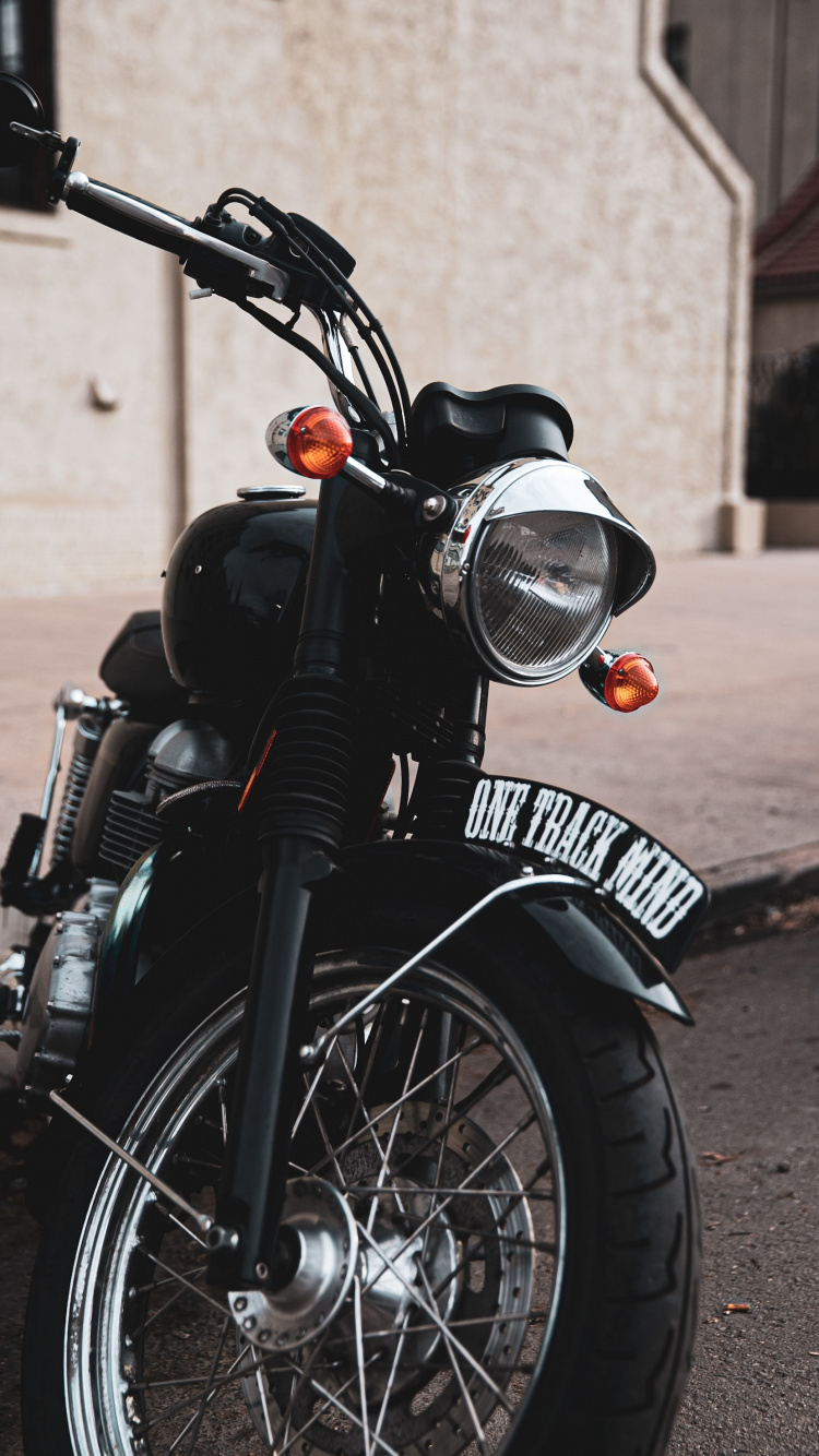 Schwarzes Motorrad Auf Der Straße Geparkt. Wallpaper in 750x1334 Resolution