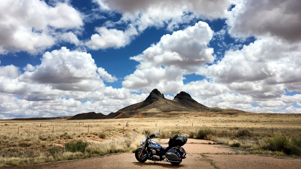 Motocicleta Negra en Campo Marrón Bajo Nubes Blancas y Cielo Azul Durante el Día. Wallpaper in 1280x720 Resolution