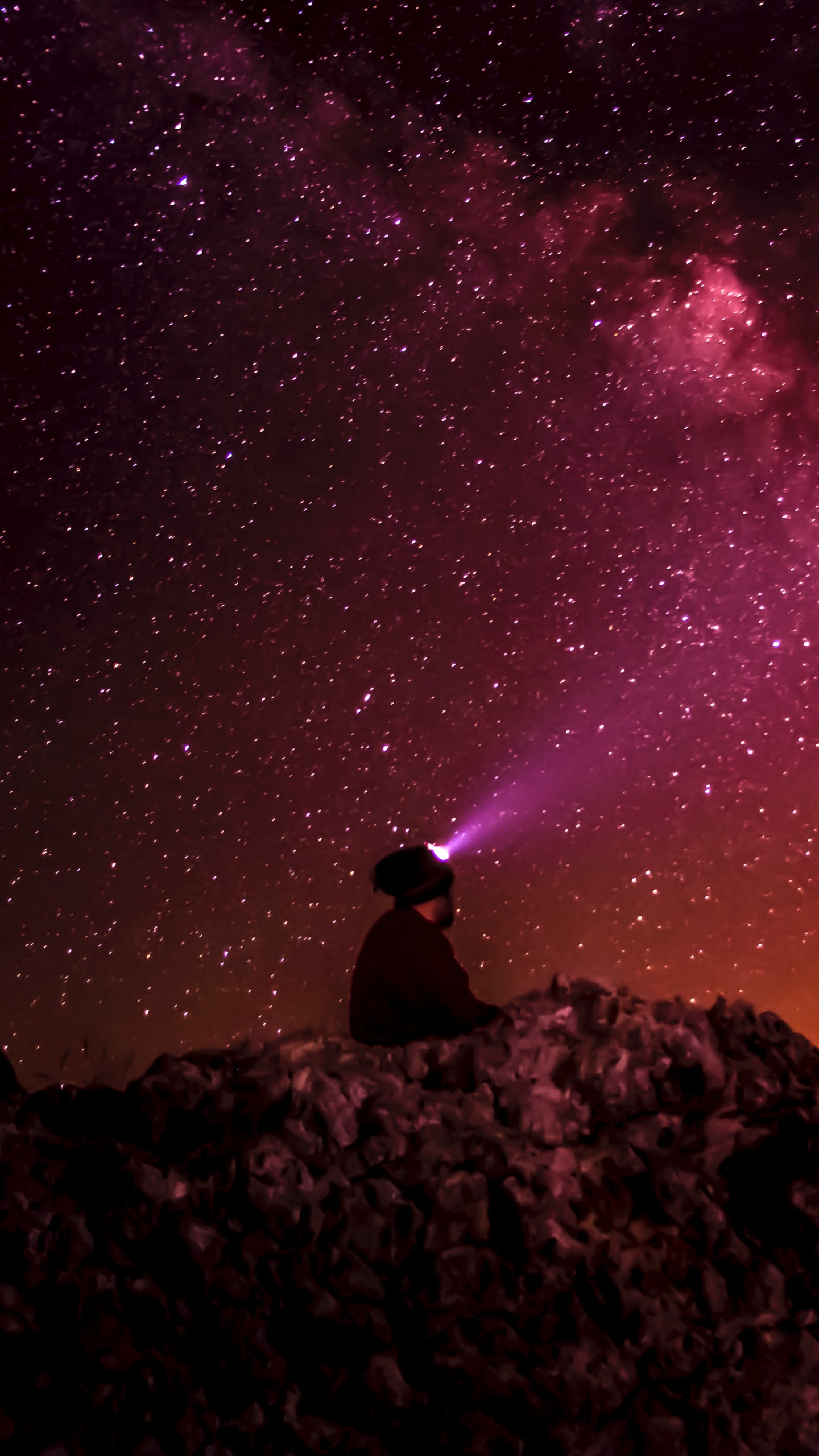 Man Sitting on Rock Under Starry Night. Wallpaper in 1440x2560 Resolution