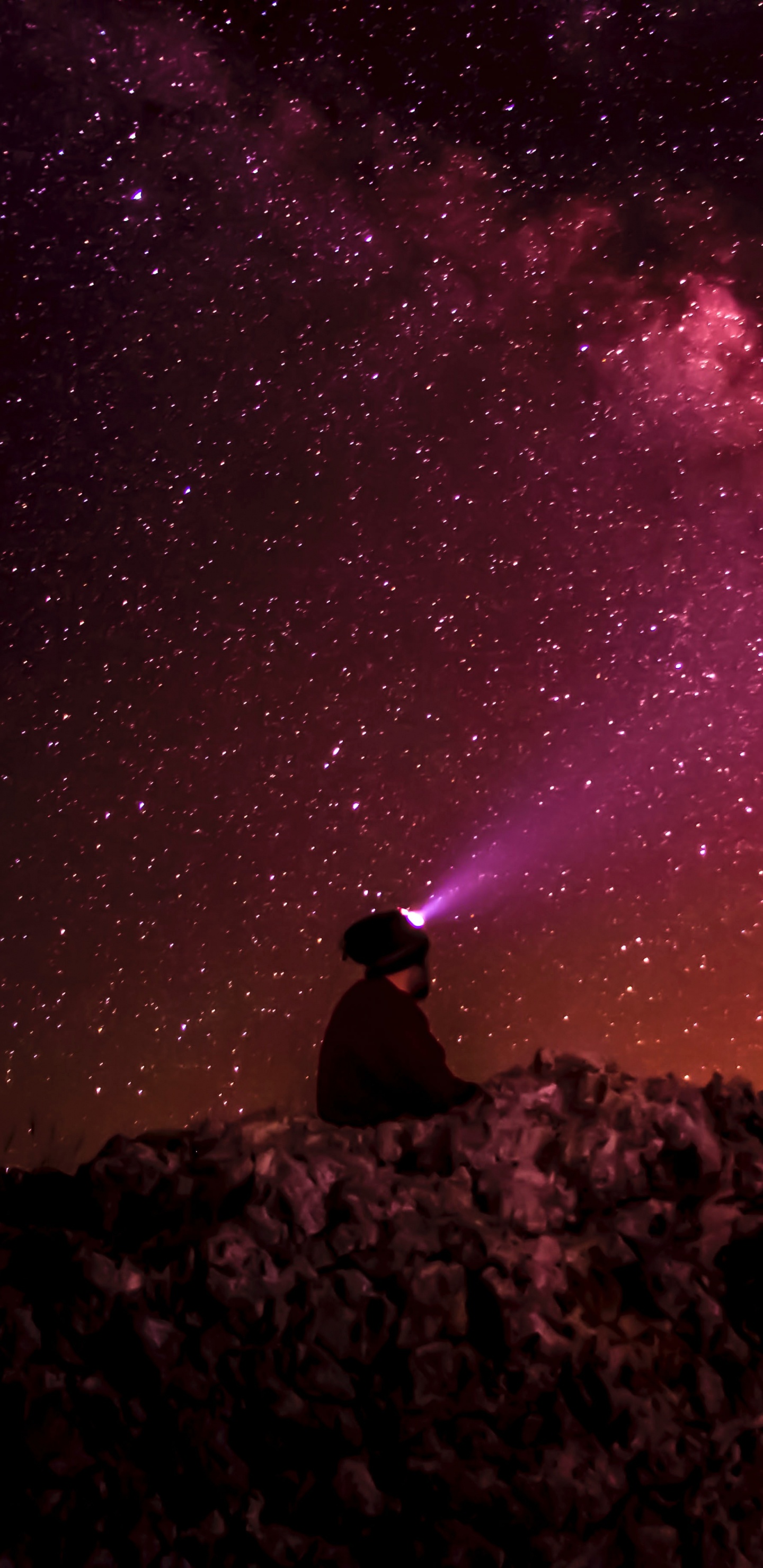 Man Sitting on Rock Under Starry Night. Wallpaper in 1440x2960 Resolution