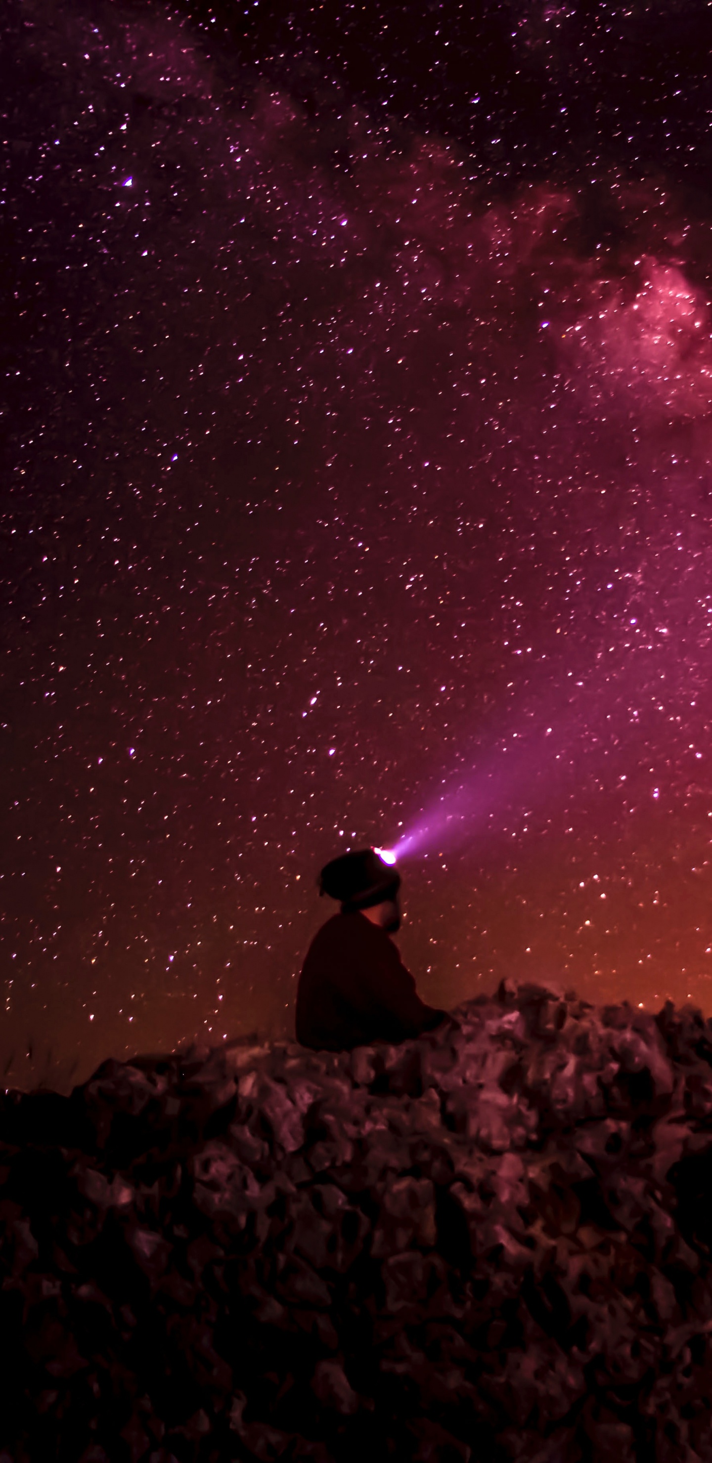 Hombre Sentado Sobre Una Roca Bajo la Noche Estrellada. Wallpaper in 1440x2960 Resolution