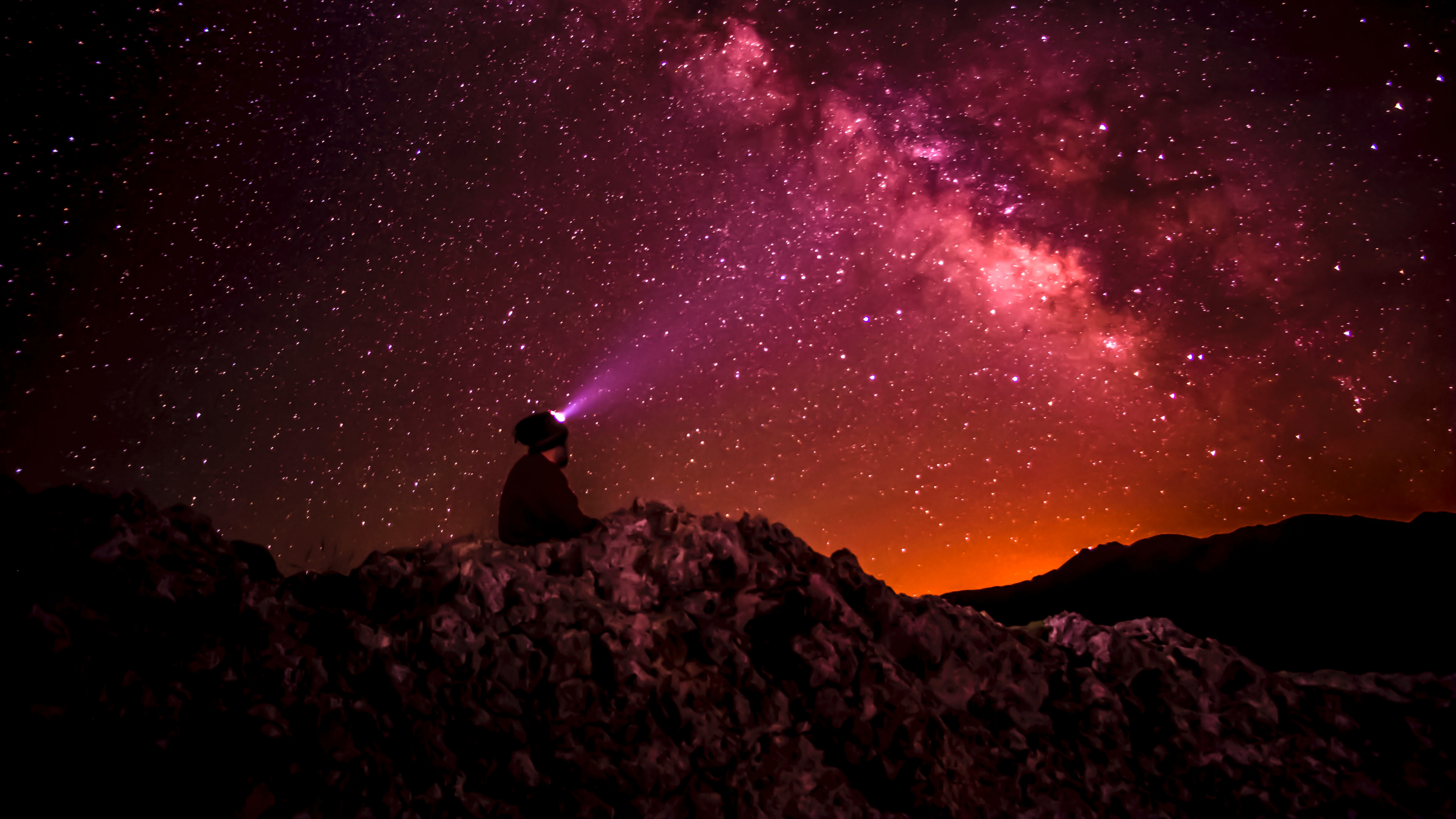 Hombre Sentado Sobre Una Roca Bajo la Noche Estrellada. Wallpaper in 3840x2160 Resolution