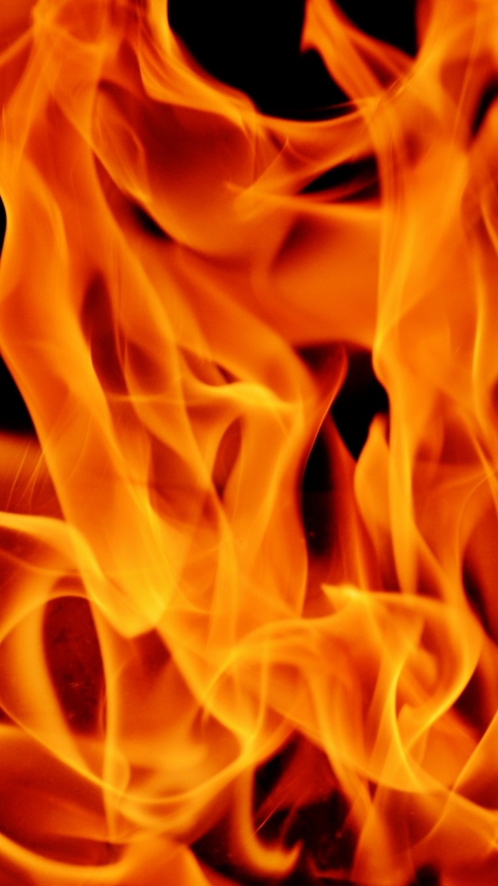 Orange Fire in Black Background. Wallpaper in 720x1280 Resolution