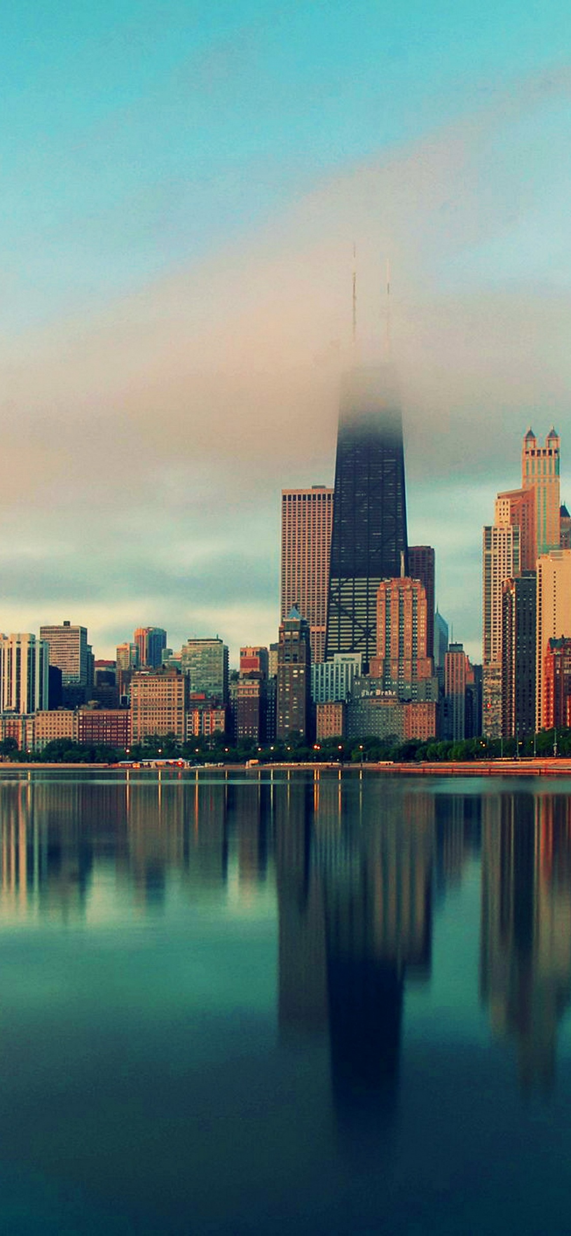 City Skyline Across Body of Water During Daytime. Wallpaper in 1125x2436 Resolution