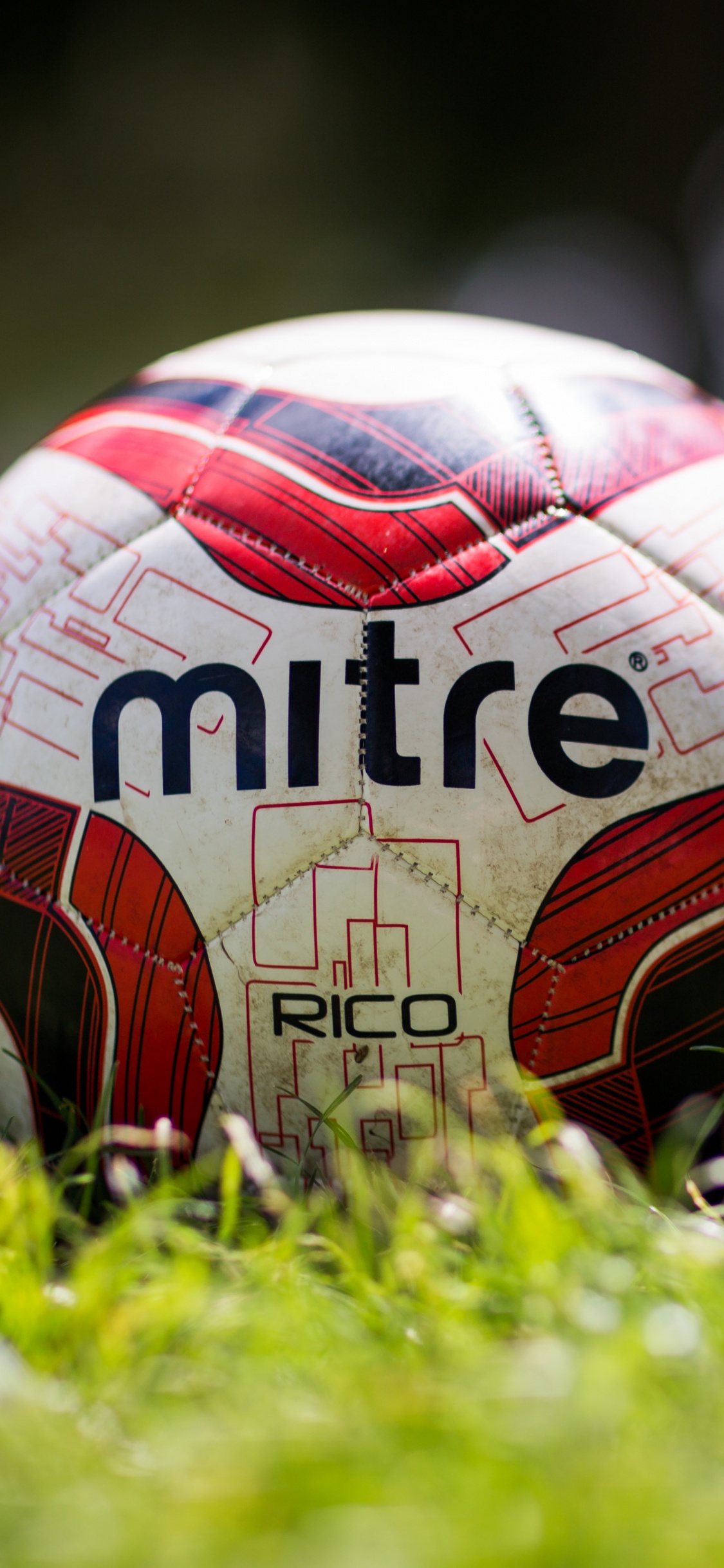 White Red and Black Soccer Ball on Green Grass Field During Daytime. Wallpaper in 1125x2436 Resolution