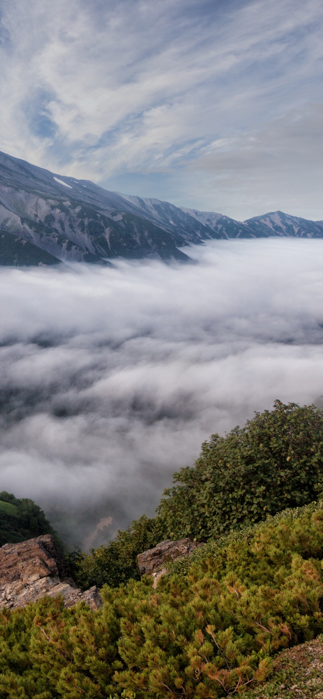 Montaña Verde y Negra Bajo Nubes Blancas Durante el Día. Wallpaper in 1125x2436 Resolution