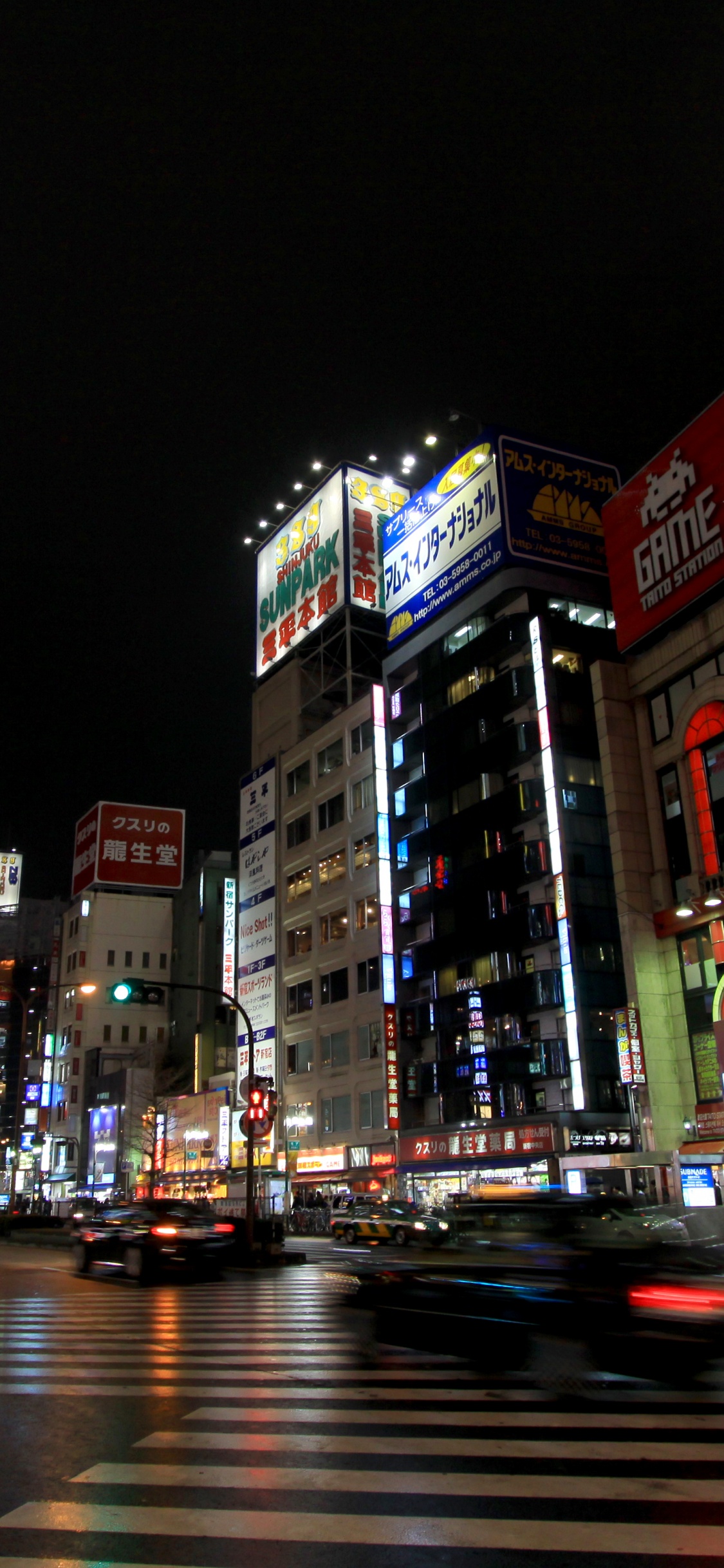 Cars on Road Near Buildings During Night Time. Wallpaper in 1125x2436 Resolution