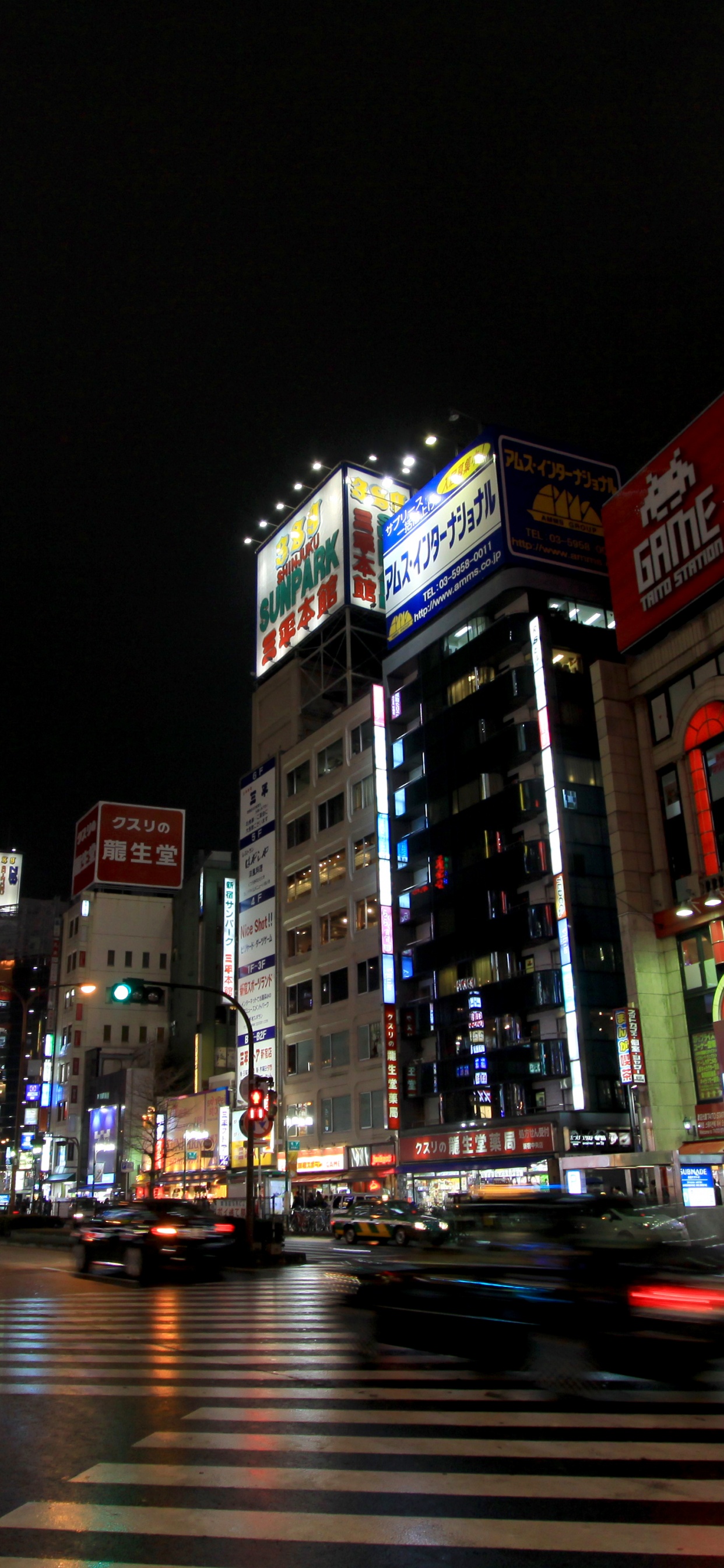 Cars on Road Near Buildings During Night Time. Wallpaper in 1242x2688 Resolution