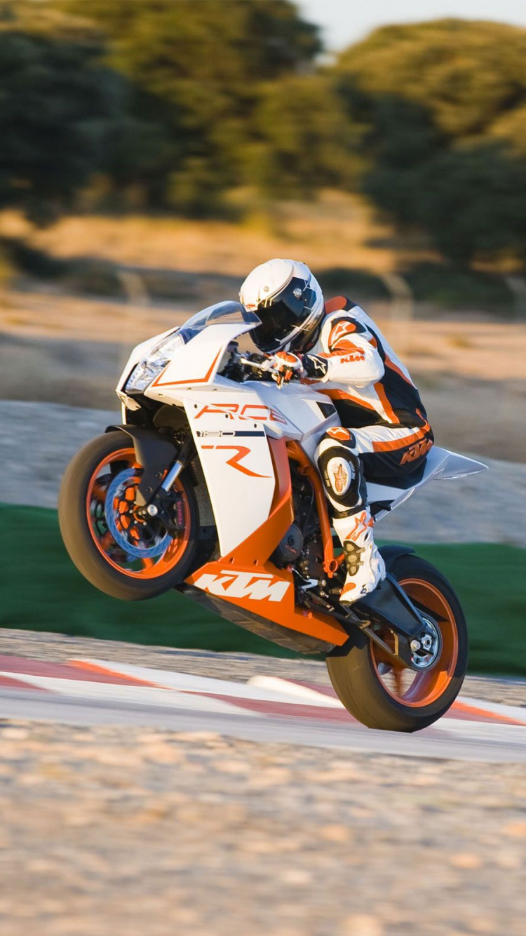 Mann, Der Tagsüber Orangefarbenes Dirtbike Auf Der Straße Fährt. Wallpaper in 750x1334 Resolution