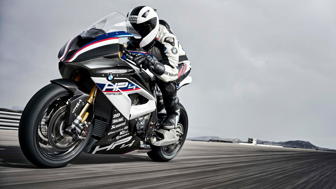 Man in Black and White Motorcycle Suit Riding on Black and White Sports Bike. Wallpaper in 1280x720 Resolution