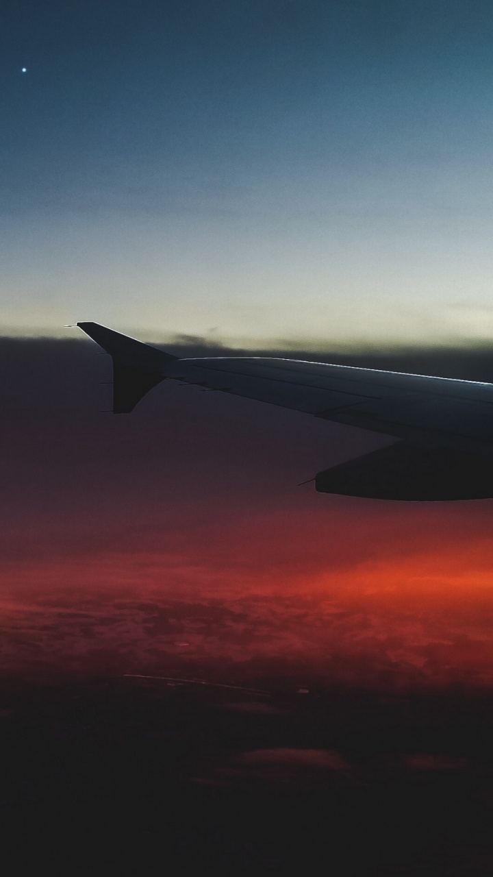 Flugzeugflügel Über Den Wolken Bei Sonnenuntergang. Wallpaper in 720x1280 Resolution