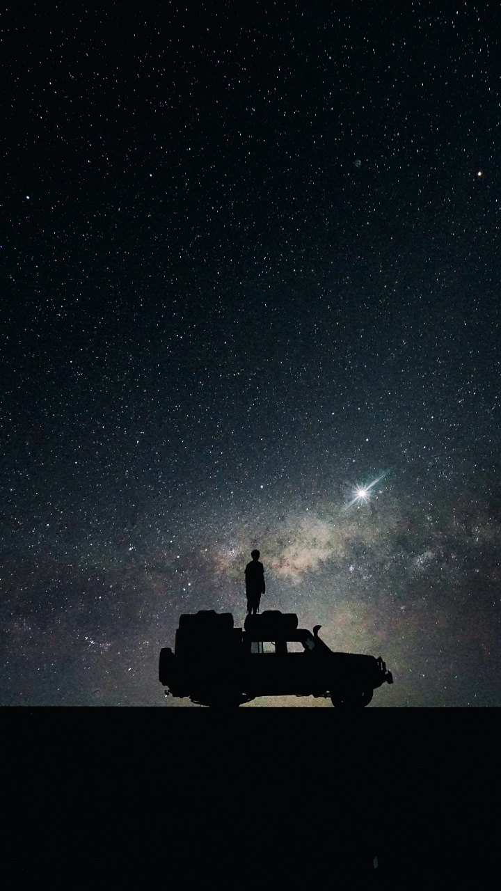 Silhouette of Man and Woman Sitting on Car Under Starry Night. Wallpaper in 720x1280 Resolution