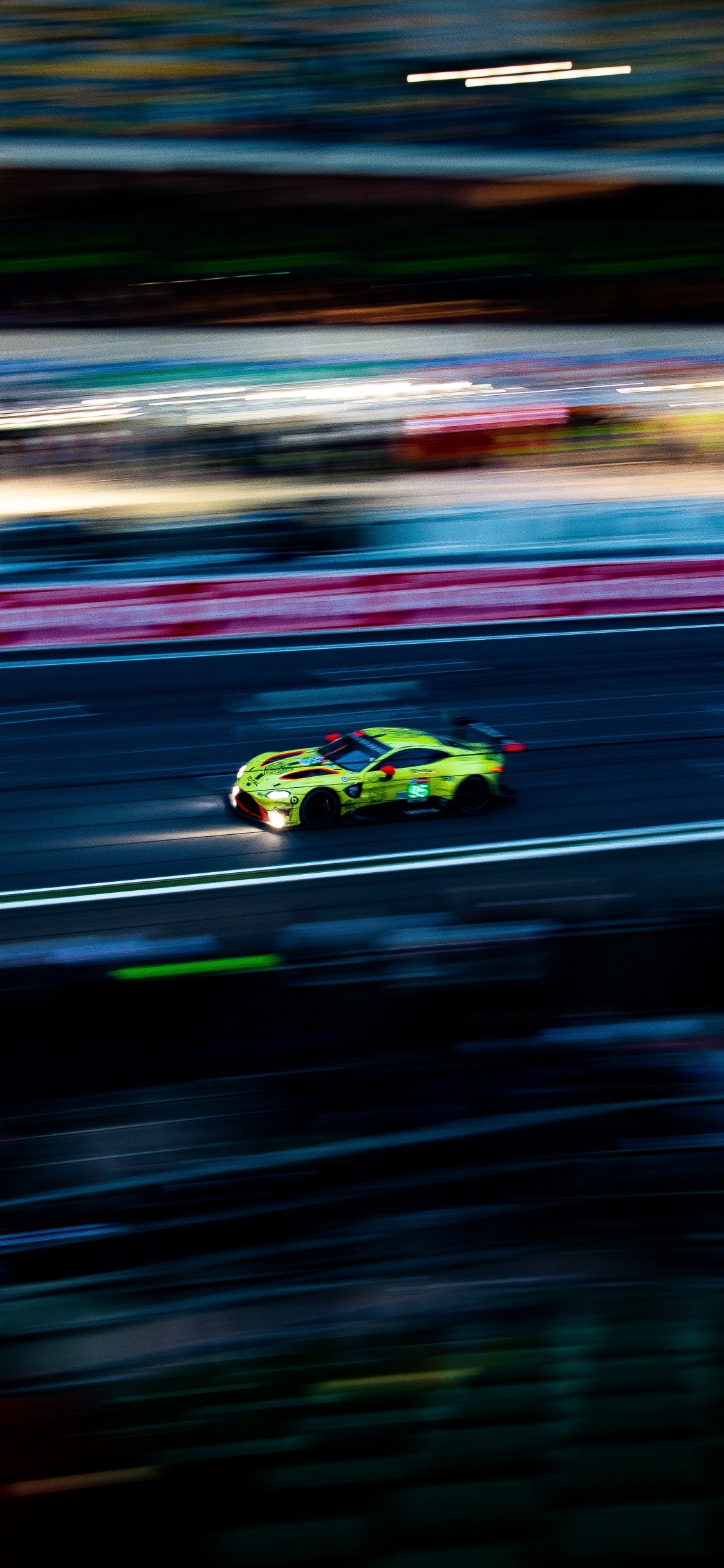 Grün-schwarzer Sportwagen Auf Der Straße. Wallpaper in 1125x2436 Resolution