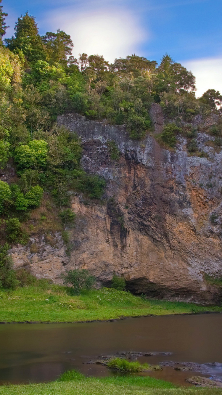 Cascadas en la Montaña Rocosa Marrón Bajo un Cielo Azul Durante el Día. Wallpaper in 750x1334 Resolution