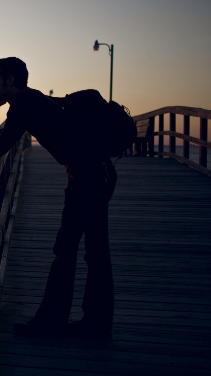 Man in Black Jacket Standing on Dock During Sunset. Wallpaper in 720x1280 Resolution