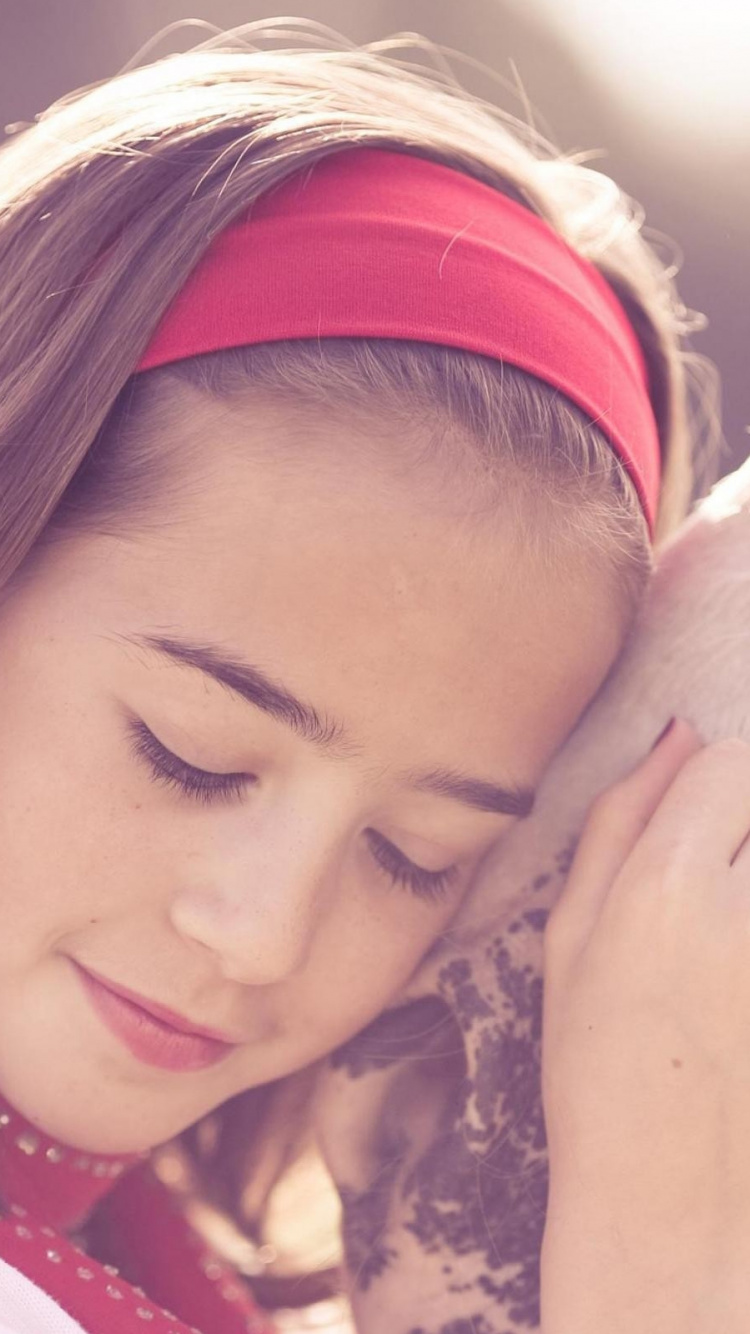 Woman in Red and White Knit Cap Kissing White Short Coated Dog. Wallpaper in 750x1334 Resolution