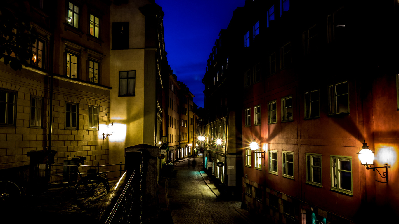 People Walking on Sidewalk Near Building During Night Time. Wallpaper in 1366x768 Resolution