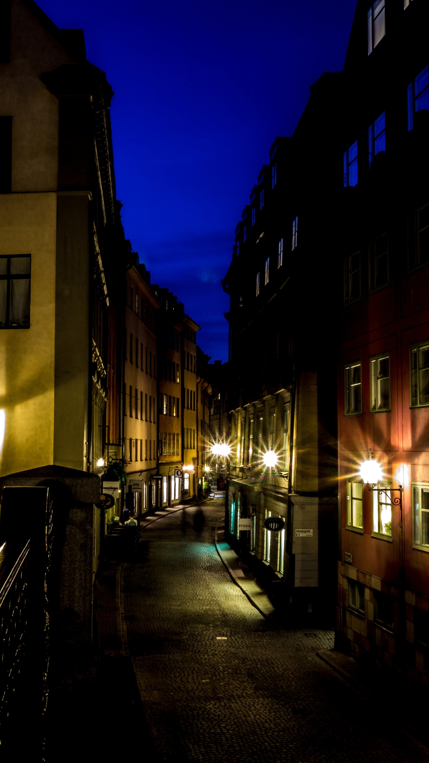 Gente Caminando en la Acera Cerca Del Edificio Durante la Noche. Wallpaper in 1440x2560 Resolution