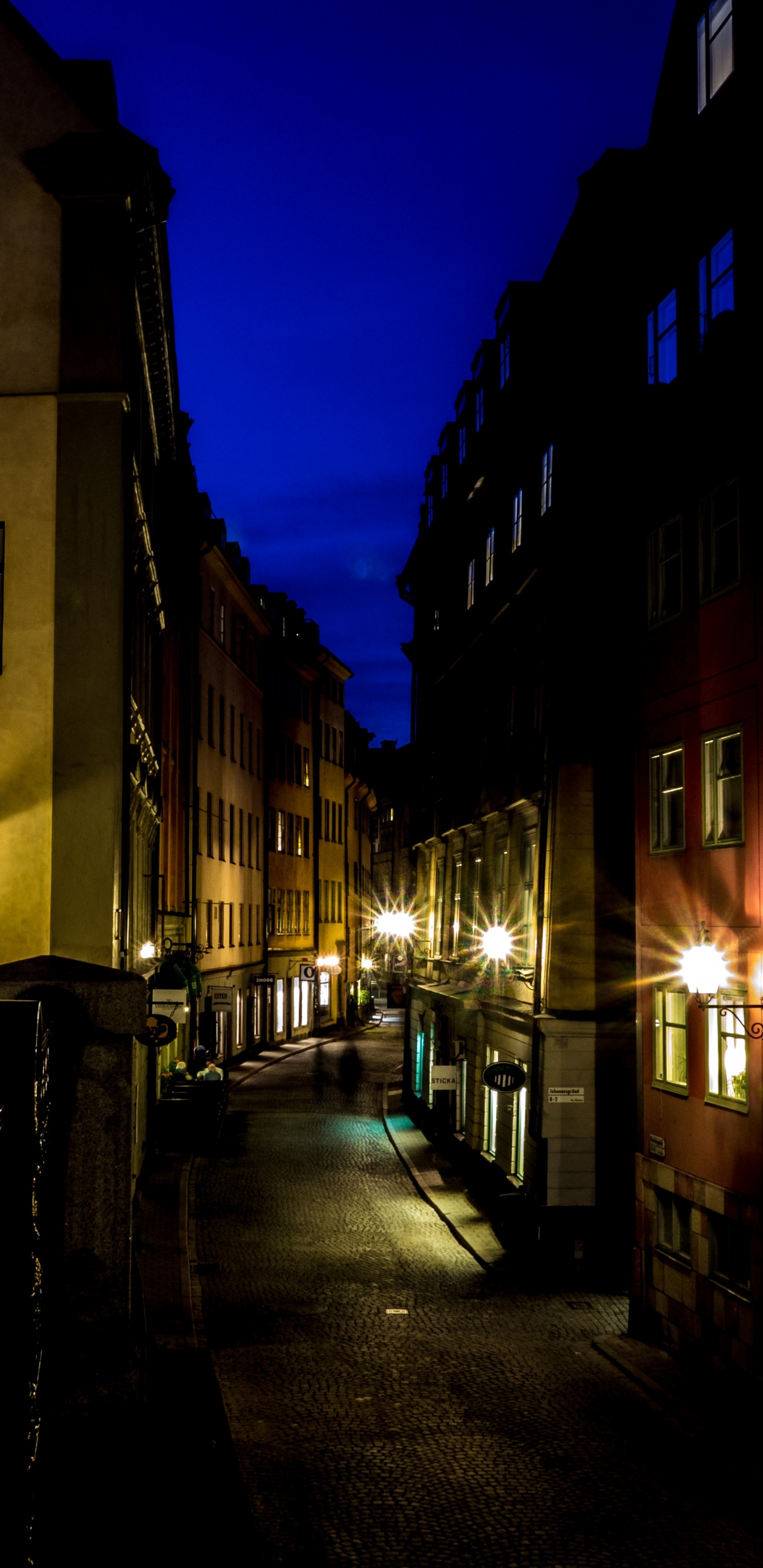 Personnes Marchant Sur le Trottoir Près du Bâtiment Pendant la Nuit. Wallpaper in 1440x2960 Resolution