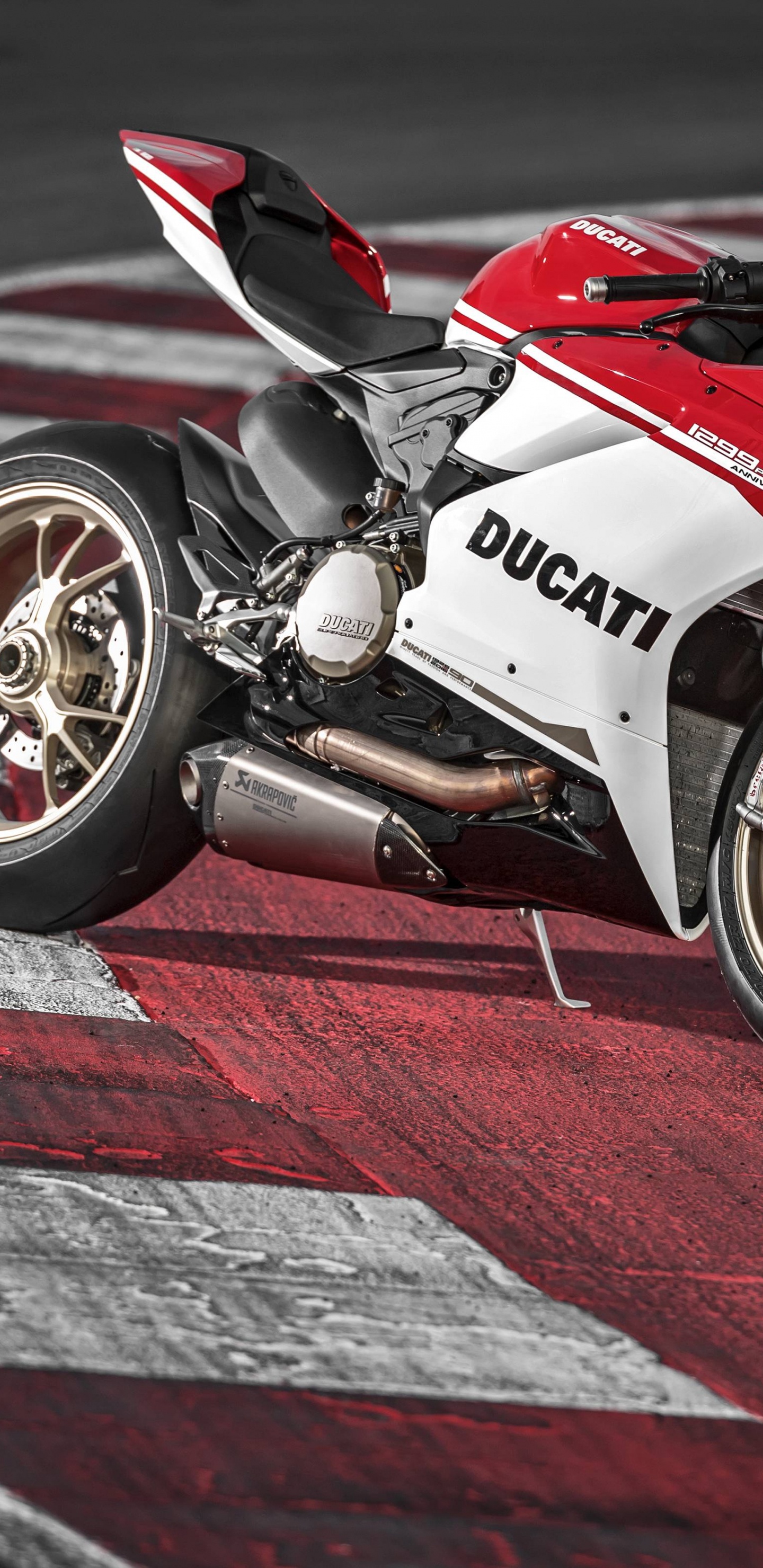 Vélo de Sport Rouge et Blanc Sur Piste. Wallpaper in 1440x2960 Resolution