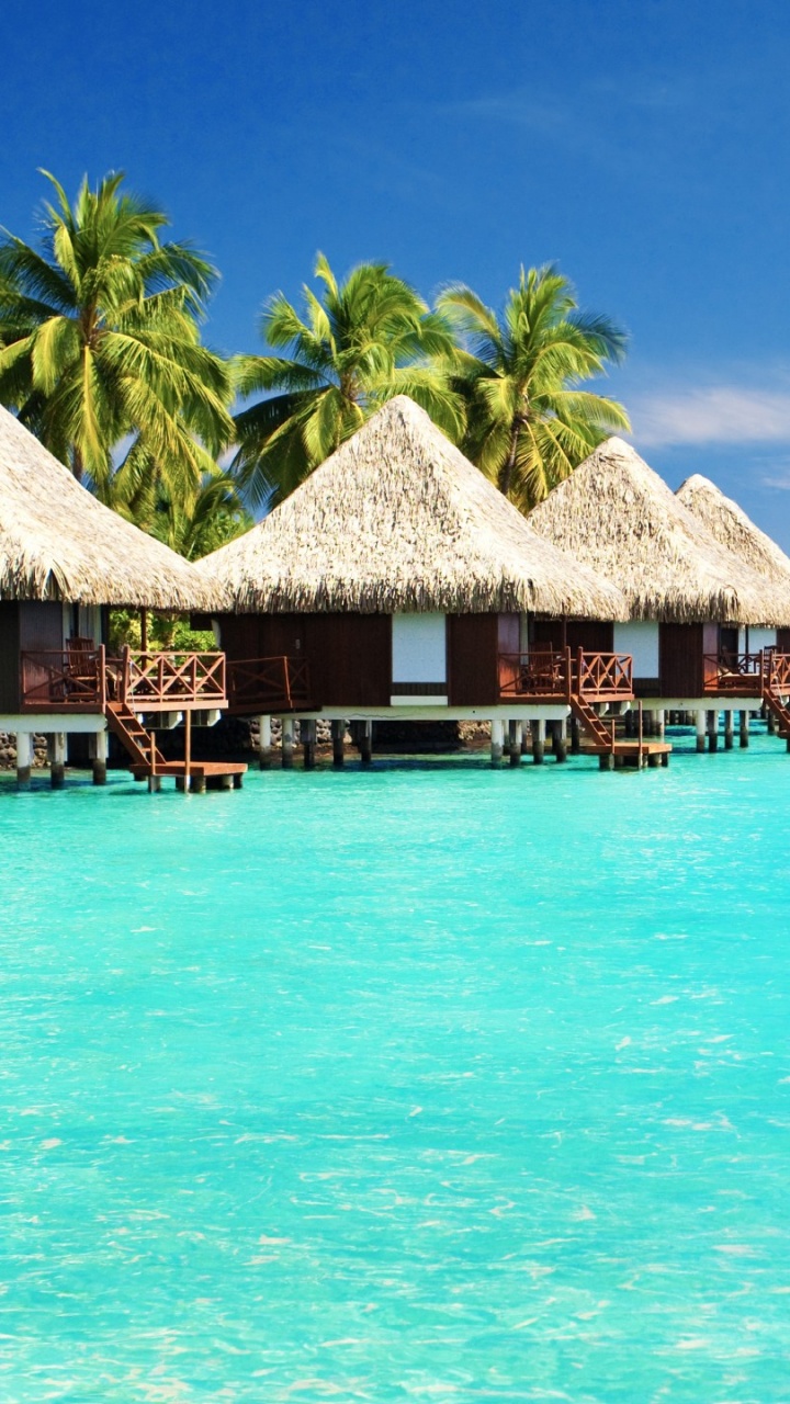 Casa de Playa de Madera Marrón en el Mar Azul Bajo un Cielo Azul Durante el Día. Wallpaper in 720x1280 Resolution