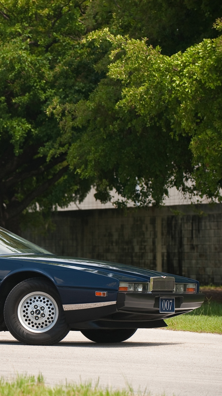 Blaue Limousine Tagsüber in Der Nähe Grüner Bäume Geparkt. Wallpaper in 750x1334 Resolution