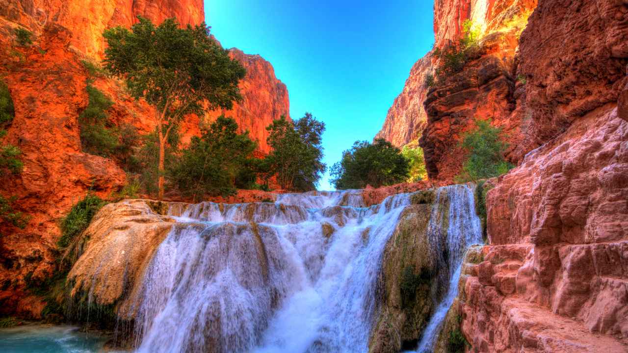 Waterfalls Between Brown Rocky Mountain Under Blue Sky During Daytime. Wallpaper in 1280x720 Resolution