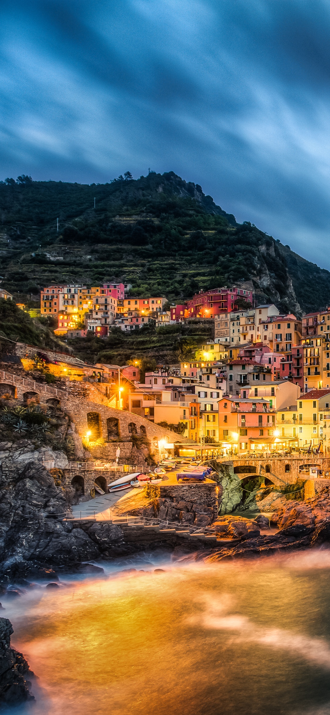 Brauner Und Grüner Berg Neben Gewässer Unter Bewölktem Himmel Tagsüber. Wallpaper in 1125x2436 Resolution