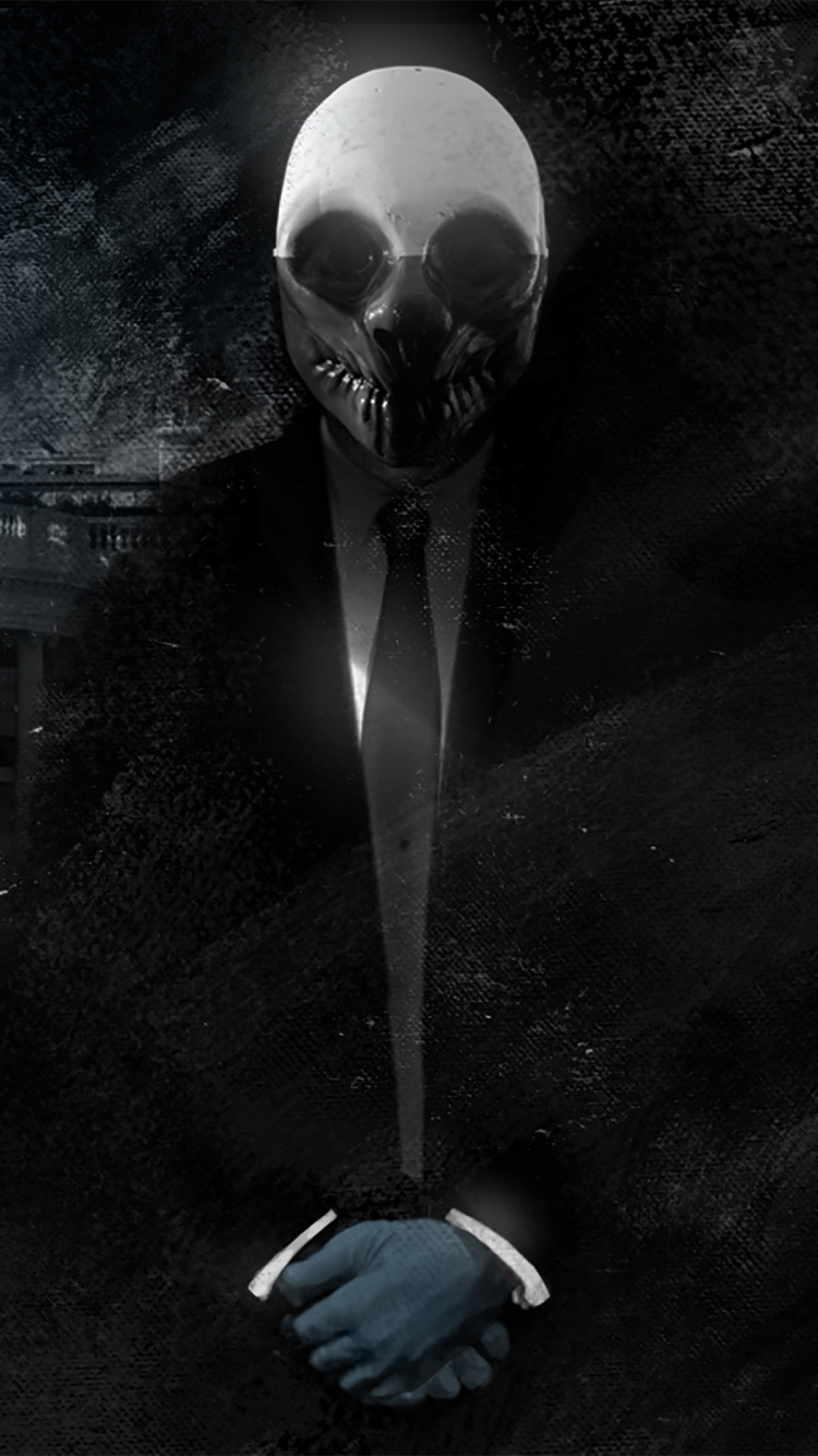 Person in Black Jacket Standing Near White Building During Night Time. Wallpaper in 750x1334 Resolution