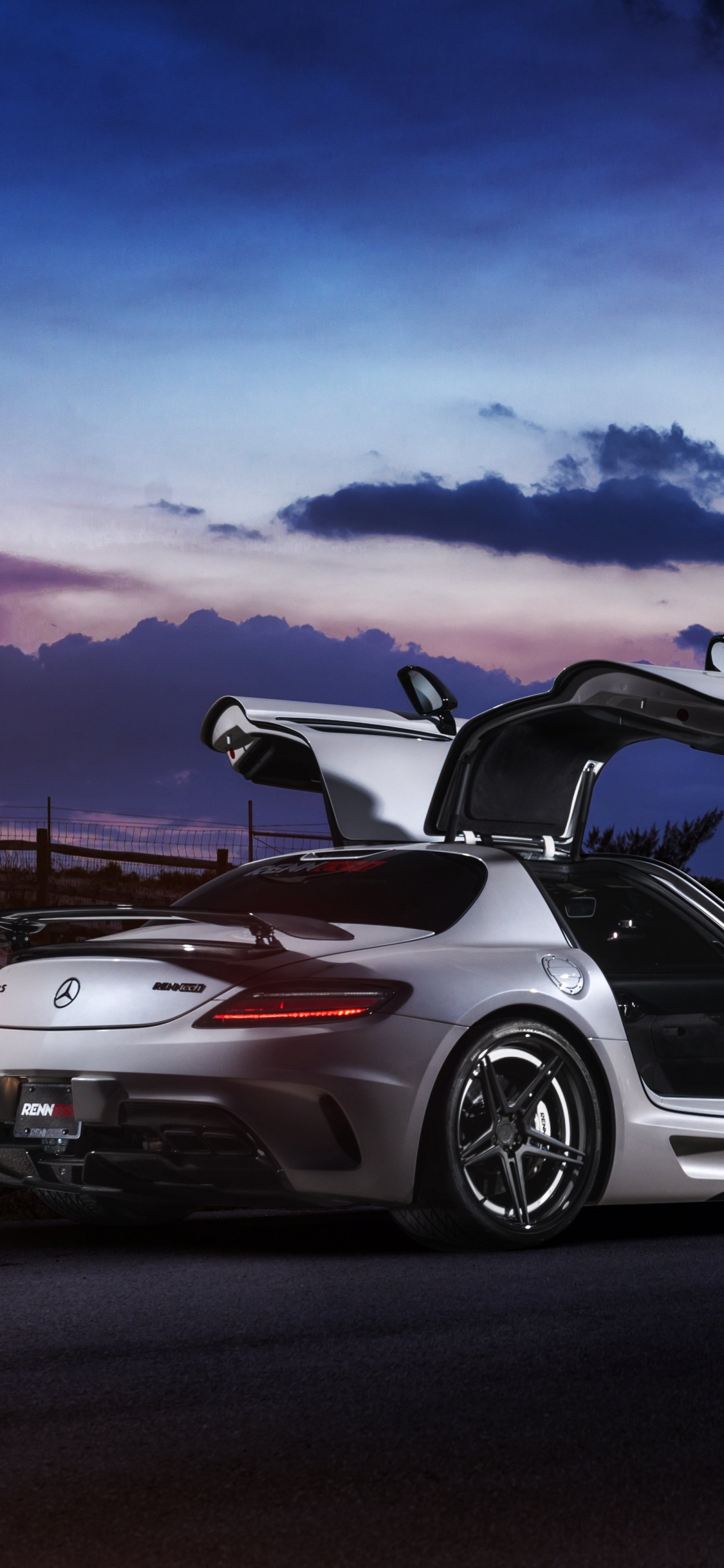 Weiß-schwarzer Porsche 911 Unterwegs Unter Blauem Himmel. Wallpaper in 1125x2436 Resolution